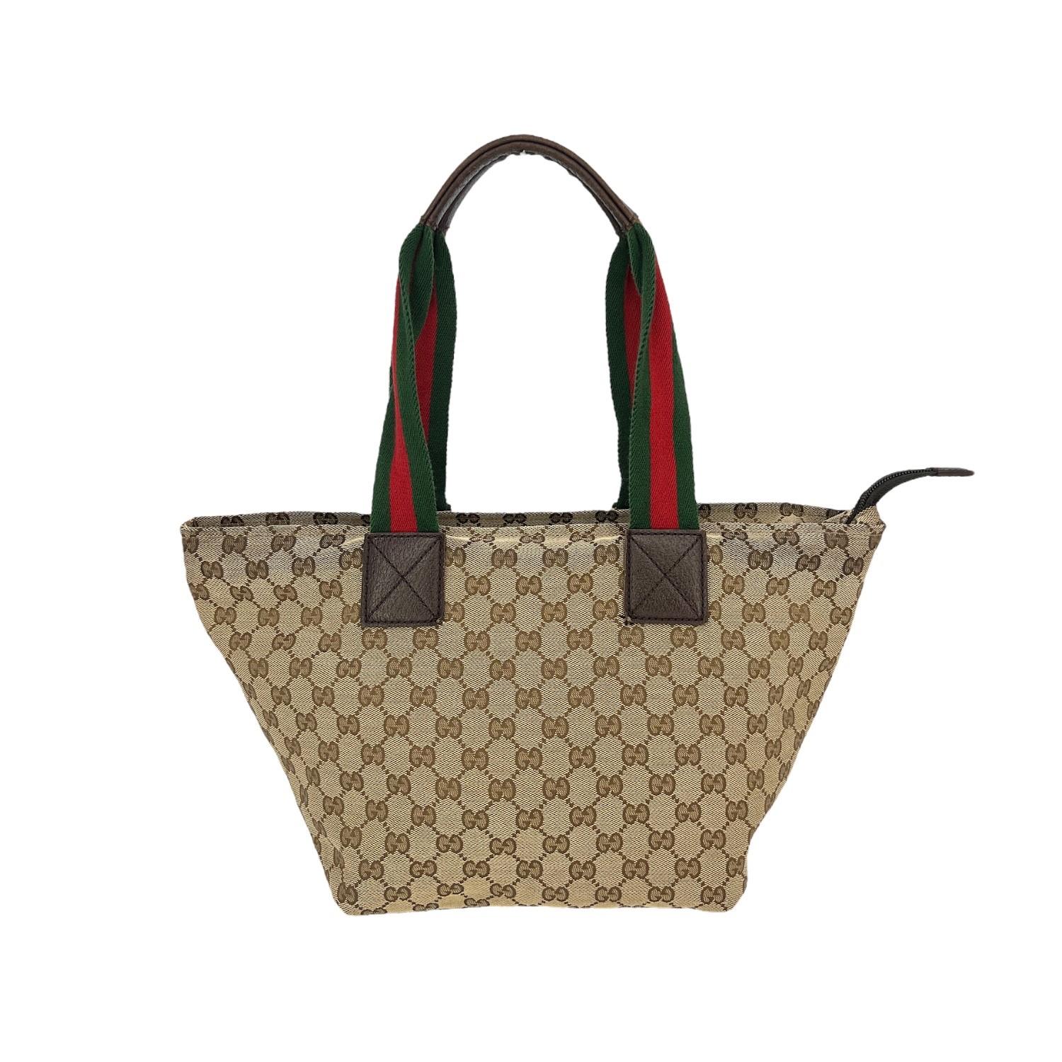 This Gucci GG Canvas Medium Web Tote was made in Italy and it is finely crafted of the classic Gucci GG Monogram canvas with leather trimming. It has dual Gucci Web shoulder straps. It has a zipper closure that opens up to a brown twill interior