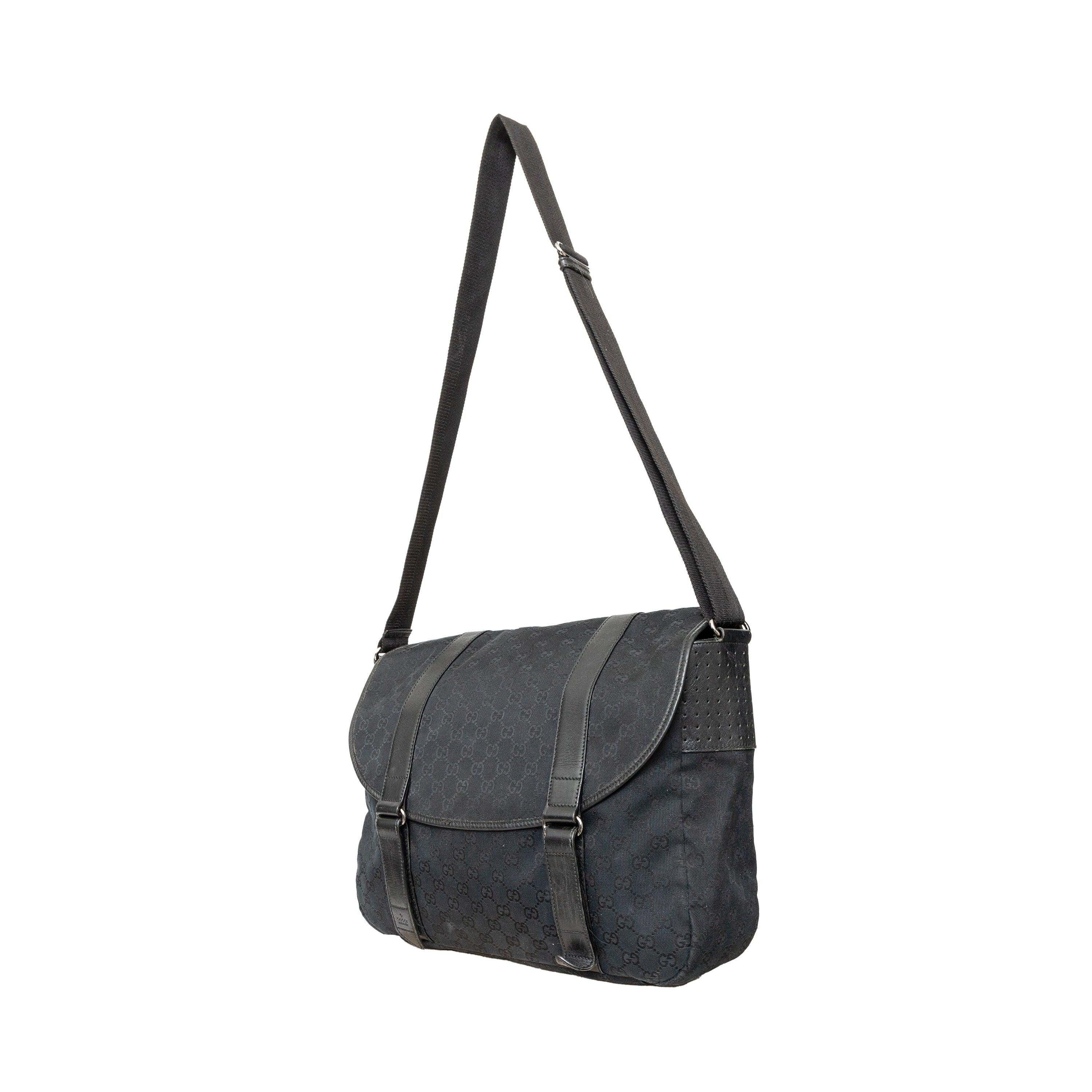 This black monogram GG canvas bag features a double buckle flap, adjustable crossbody strap, leather straps with dark silver buckles, and a black fabric interior with pockets. 
 Remarks: There are minimal signs of wear and a curling on the leather. 