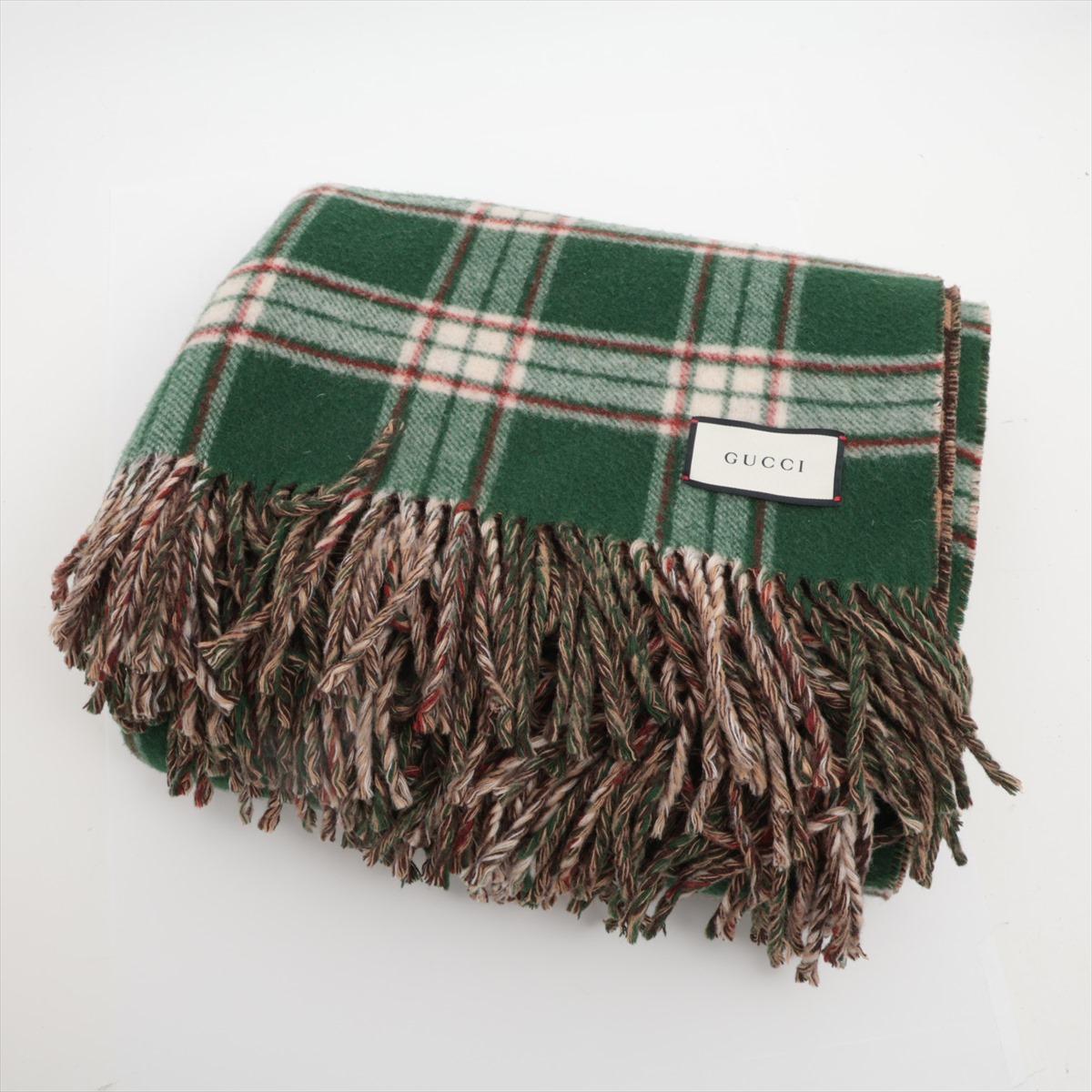 The Gucci GG Checkered Reversible Blanket in Wool Green x Brown is a sophisticated accessory that combines luxury with versatility. Crafted from soft, premium wool, it features a striking green and brown checkered pattern on one side and a timeless