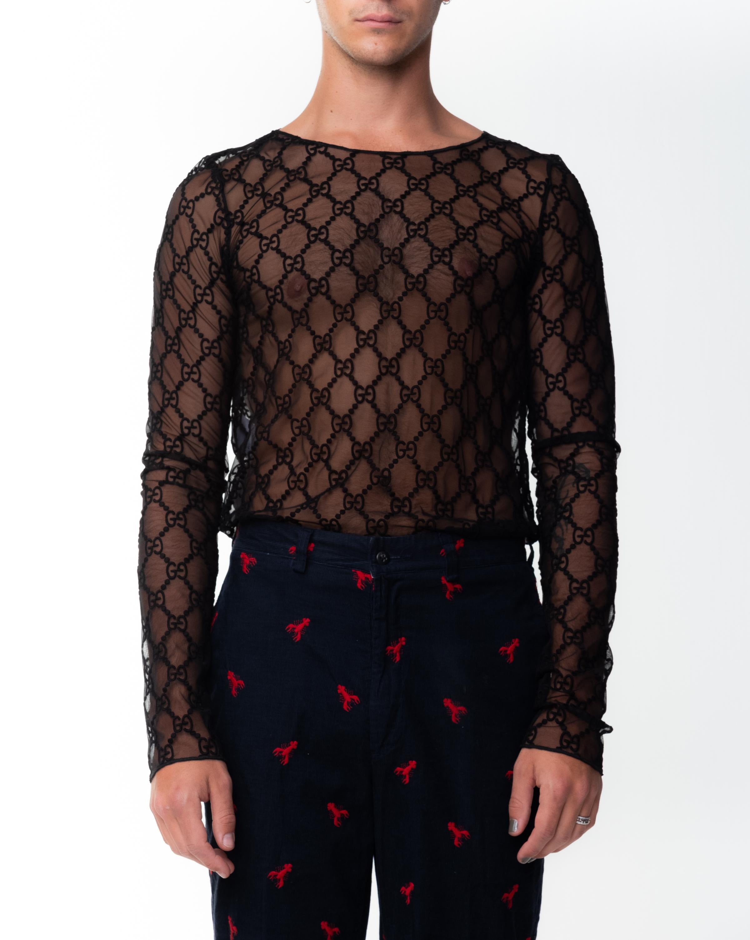 Gucci GG embroidered tull t-shirt. Featuring an unexpected mix of details, this long sleeve T-shirt combines House codes with romantic details. The historical GG pattern is embroidered in black thread onto a black tulle base. Long sleeve,