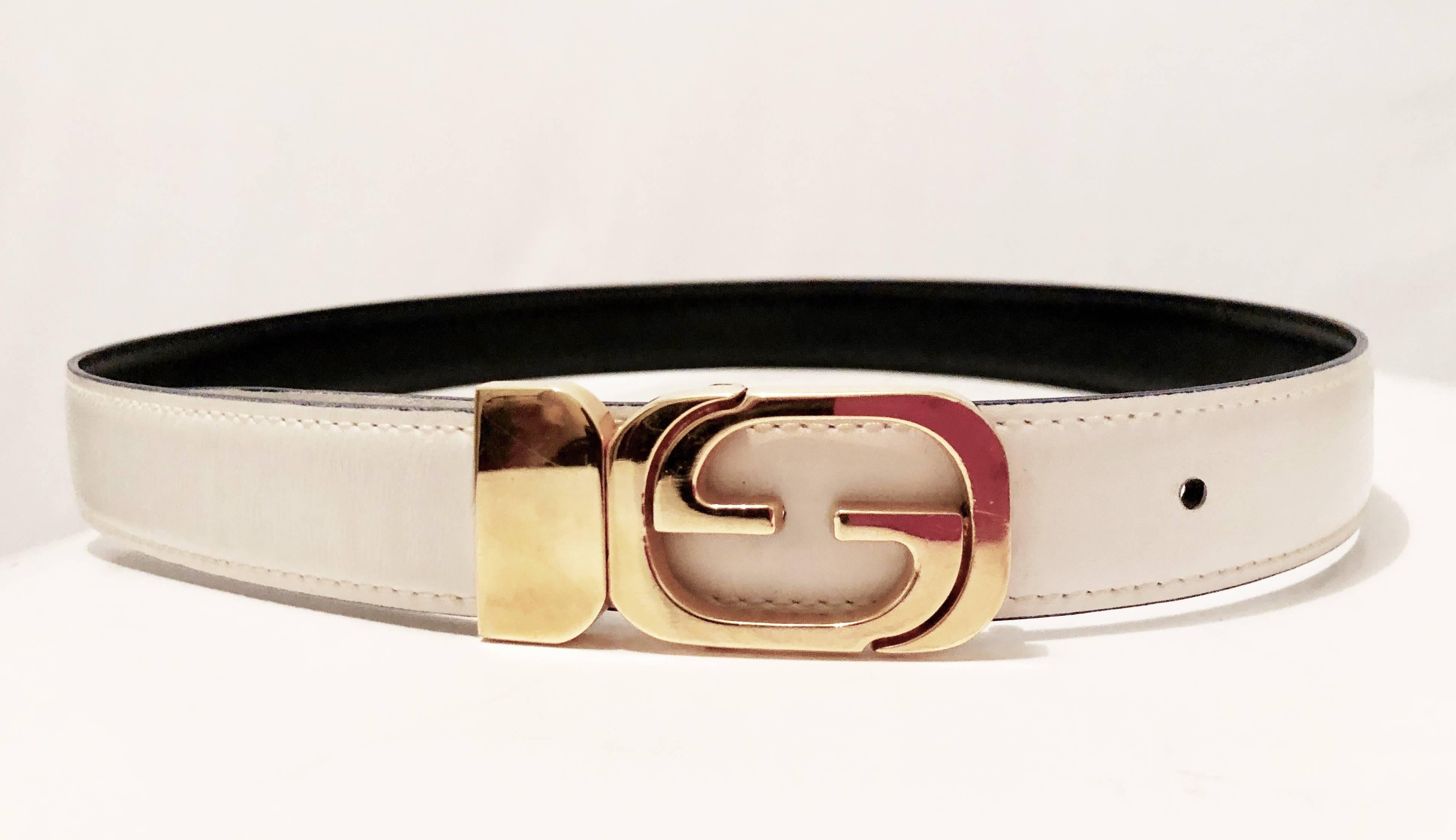This vintage Gucci belt features a reversible buckle, enabling one to wear either the black leather or white leather side.  In good preowned condition with some signs of prior wear including a few light scratches to the buckle and some light rubs to