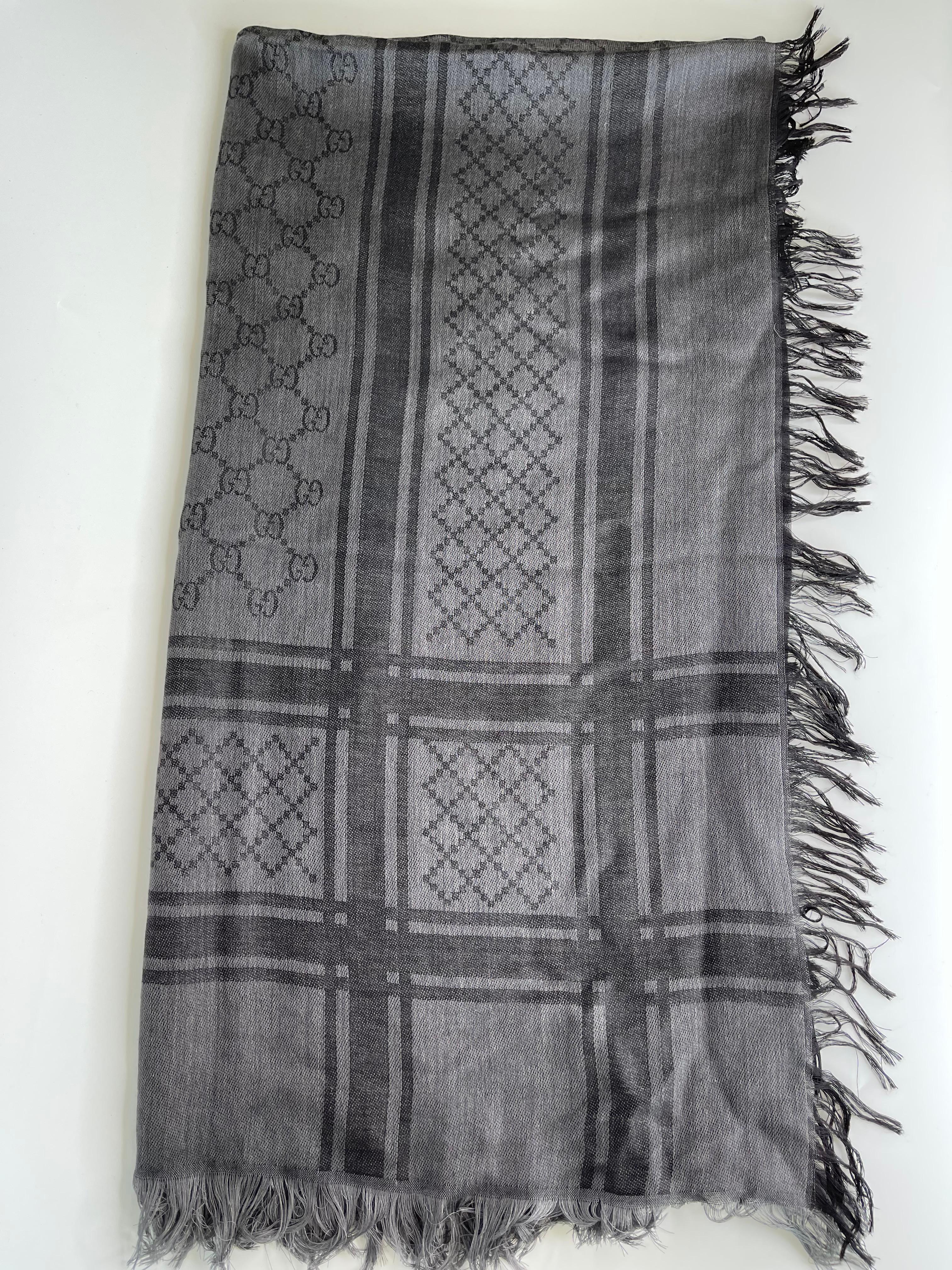 This scarf is finely crafted of 80% wool and 20% silk in a black and grey Gucci GG monogram fabric with a fringe broader.

COLOR: Black and grey
MATERIAL: 80% wool and 20% silk
ITEM CODE: 544615
MEASURES: 140 x 140 cm
COMES WITH: Box & care