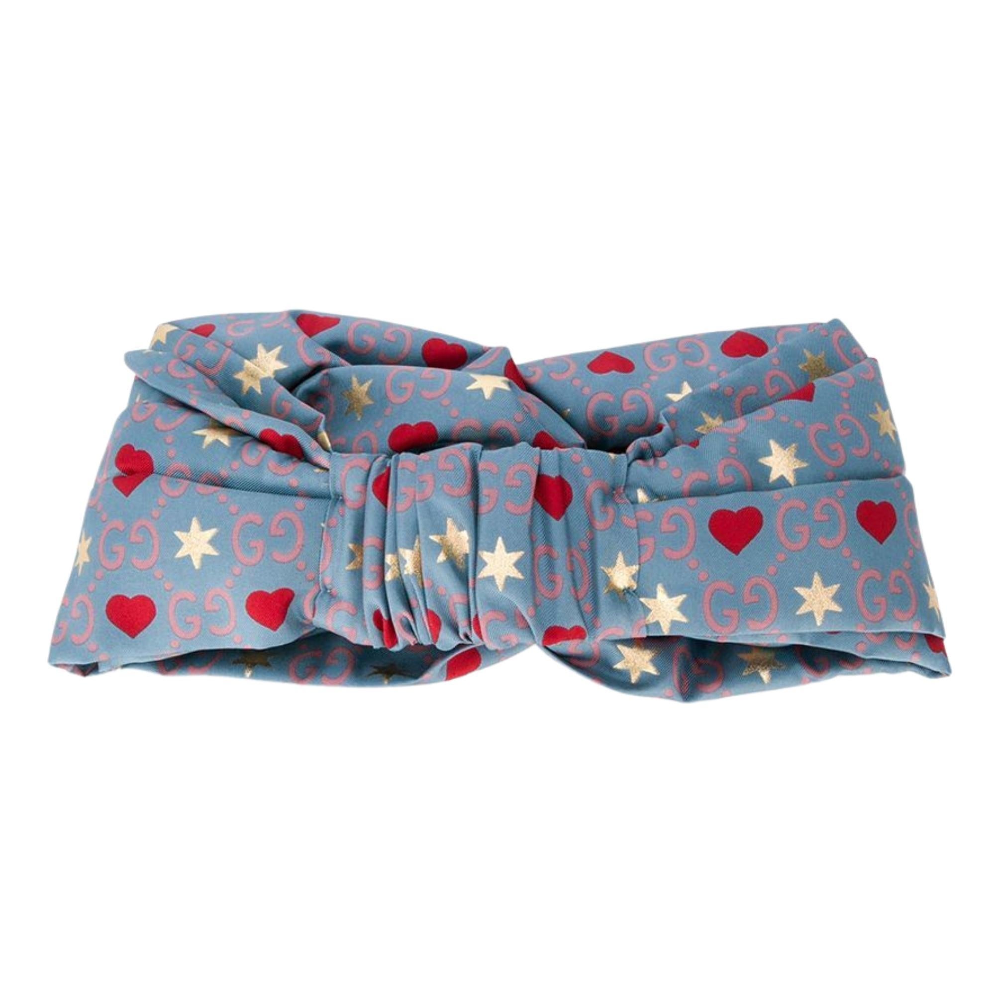 Gucci GG heart silk headband featuring a knot detail. Style with a flowy silk dress for a bohemian edit. Featuring hearts and stars with with Gucci Monogram print in pink. HB BIG DIMMBAND SE+PL TWILL

COLOR: Blue
MATERIAL: Silk & polyester
ITEM