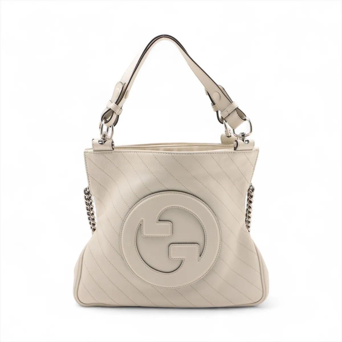 The Gucci GG Logo Blondie Leather Shoulder Tote Bag in white is a refined blend of vintage inspiration and modern sophistication. Crafted from smooth leather, it features the iconic interlocking GG logo in a bold, rounded design at the front,