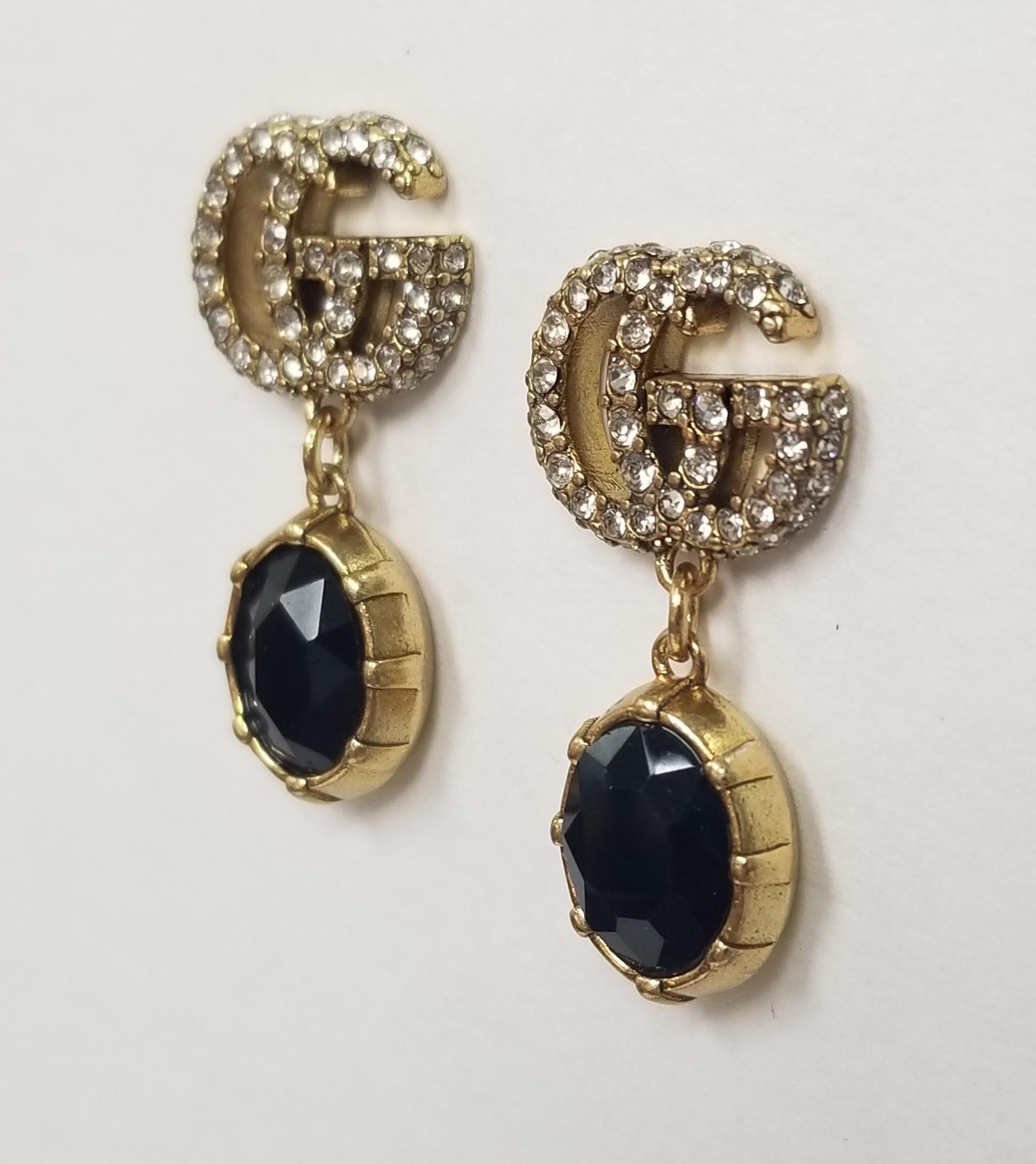  A black faceted crystal pendant combines with the crystal Double G detail, forming a sparkling pendant that completes these earrings in aged gold-toned metal.

    Metal with aged gold finish
    Crystal encrusted Double G detail
    Black crystal