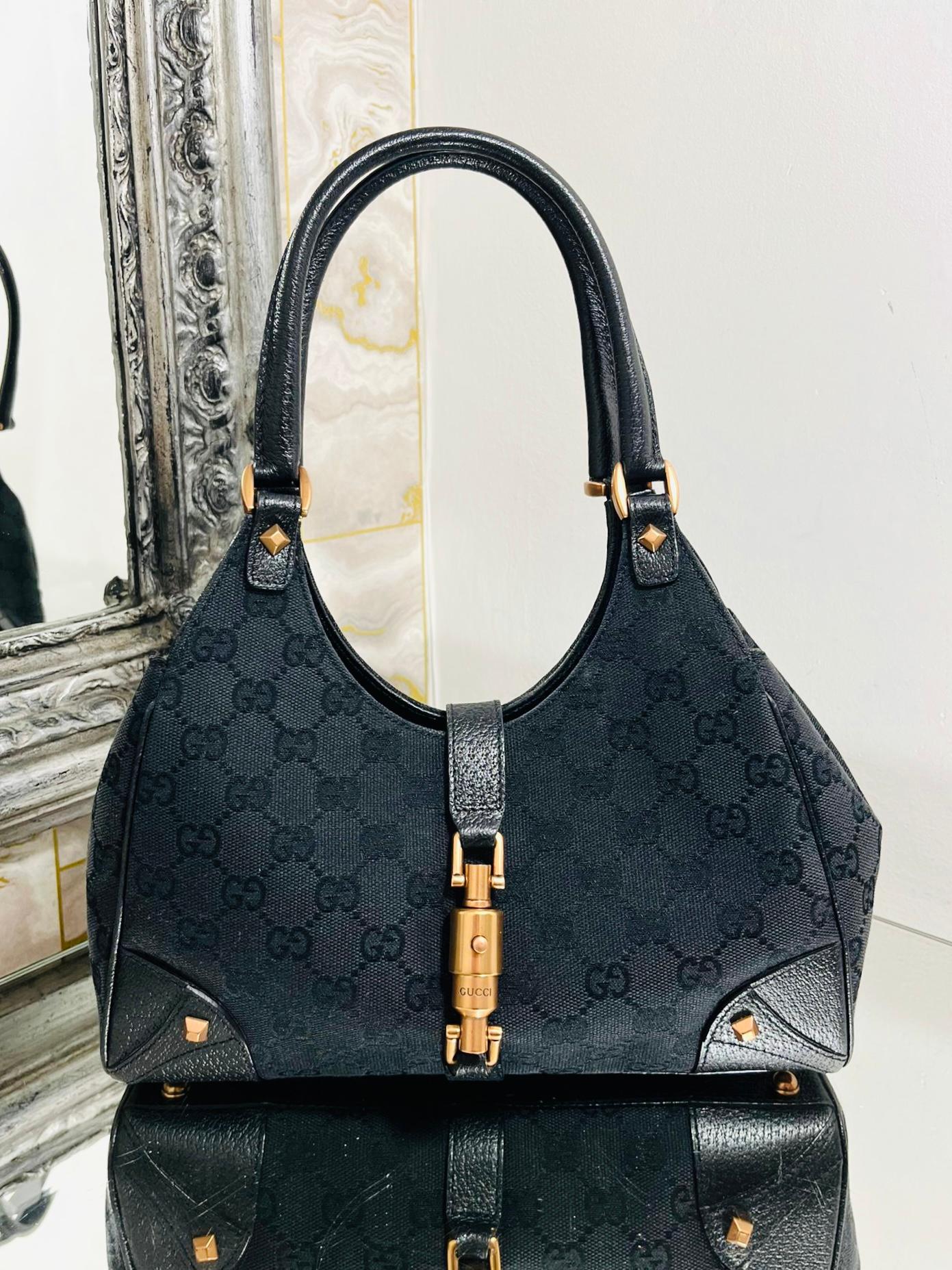 Gucci 'GG' Logo Jackie Canvas & Leather Hobo Bag

Black monogram canvas bag trimmed with leather and gold studs.

Signature Jackie push-lock closure. Two shoulder/carry handles.

Size - Height 15cm, Width 30cm, Depth 5.5cm

Condition - Vintage -