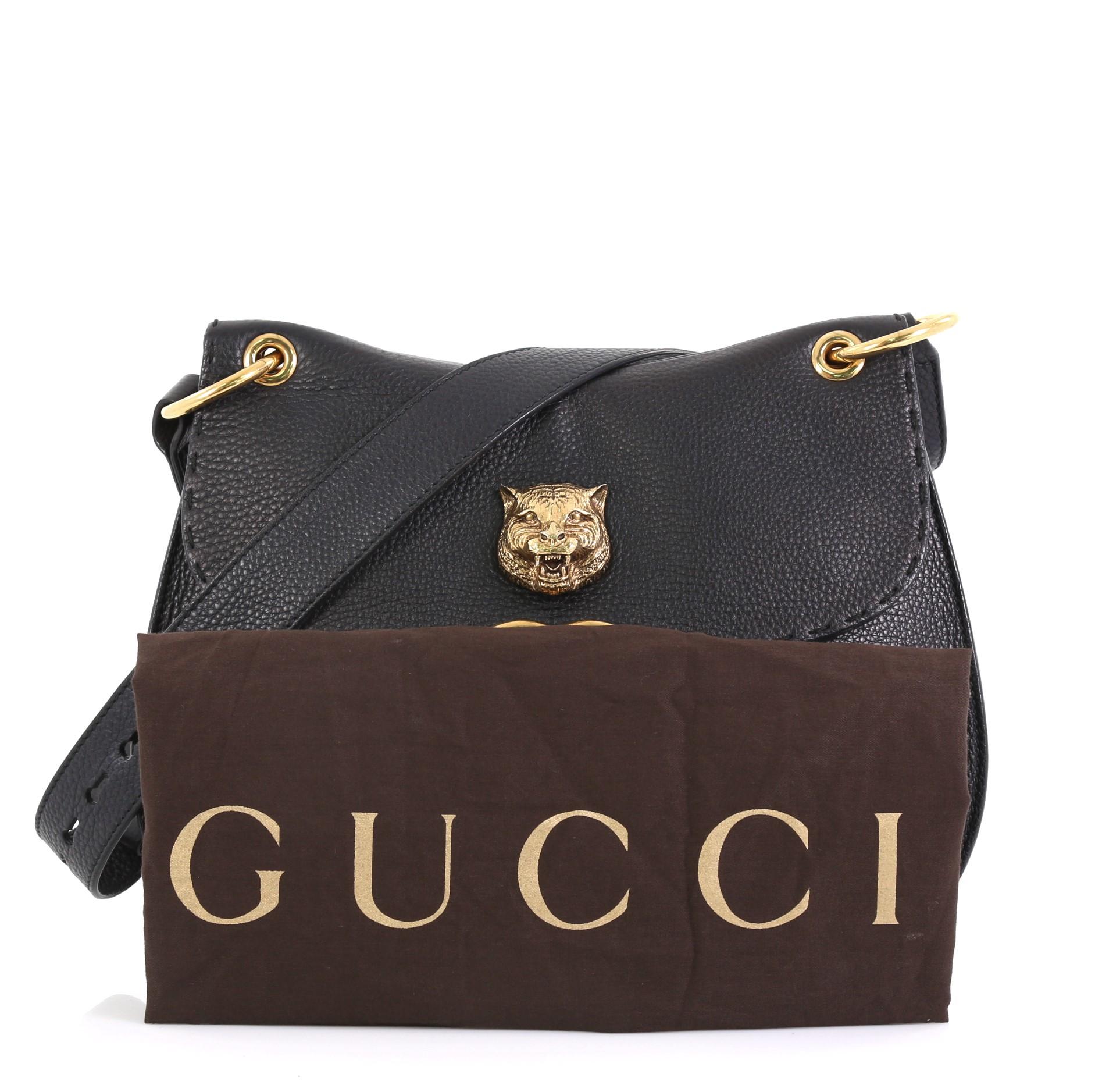 This Gucci GG Marmont Animalier Shoulder Bag Leather Medium, crafted in black leather, features long adjustable leather strap, front flap with animalier detail, and aged gold-tone hardware. Its snap button closure opens to a neutral fabric interior