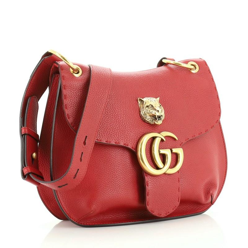 This Gucci GG Marmont Animalier Shoulder Bag Leather Medium, crafted in red leather, features an adjustable leather strap, front flap with animalier detail, and gold-tone hardware. Its snap button closure opens to a neutral fabric interior with two