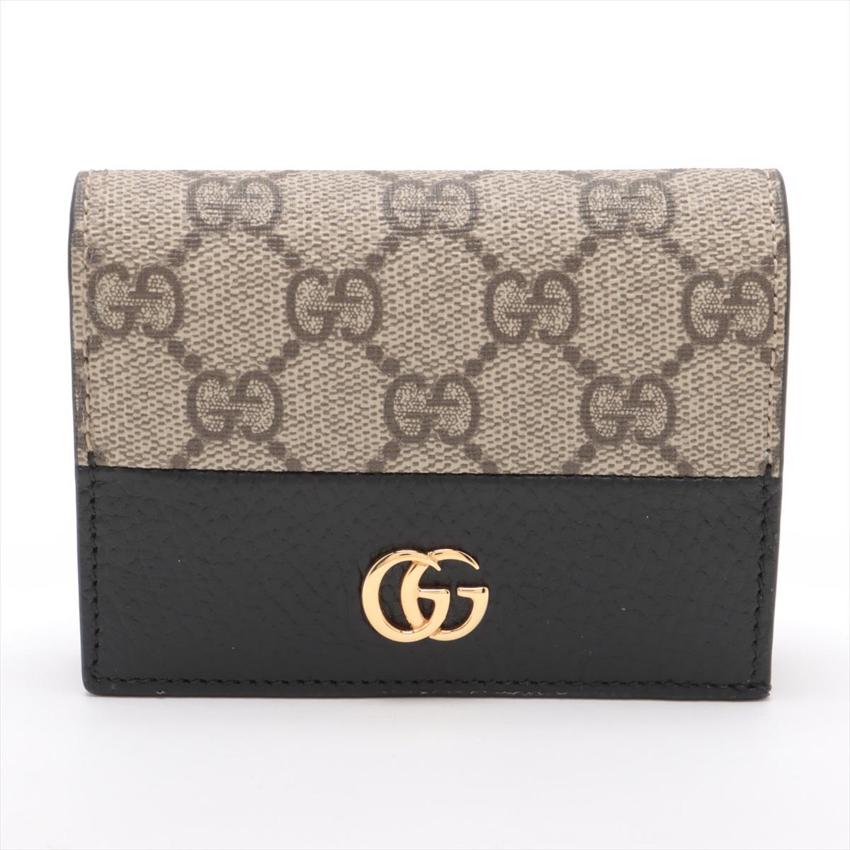 Die Gucci GG Marmont Bi-Color Leather Compact Wallet in Black × Beige verbindet zeitlose Raffinesse mit moderner Vielseitigkeit. Sie ist auf der einen Seite aus glattem schwarzem Kalbsleder und auf der anderen Seite aus geschmeidigem beigem Leder