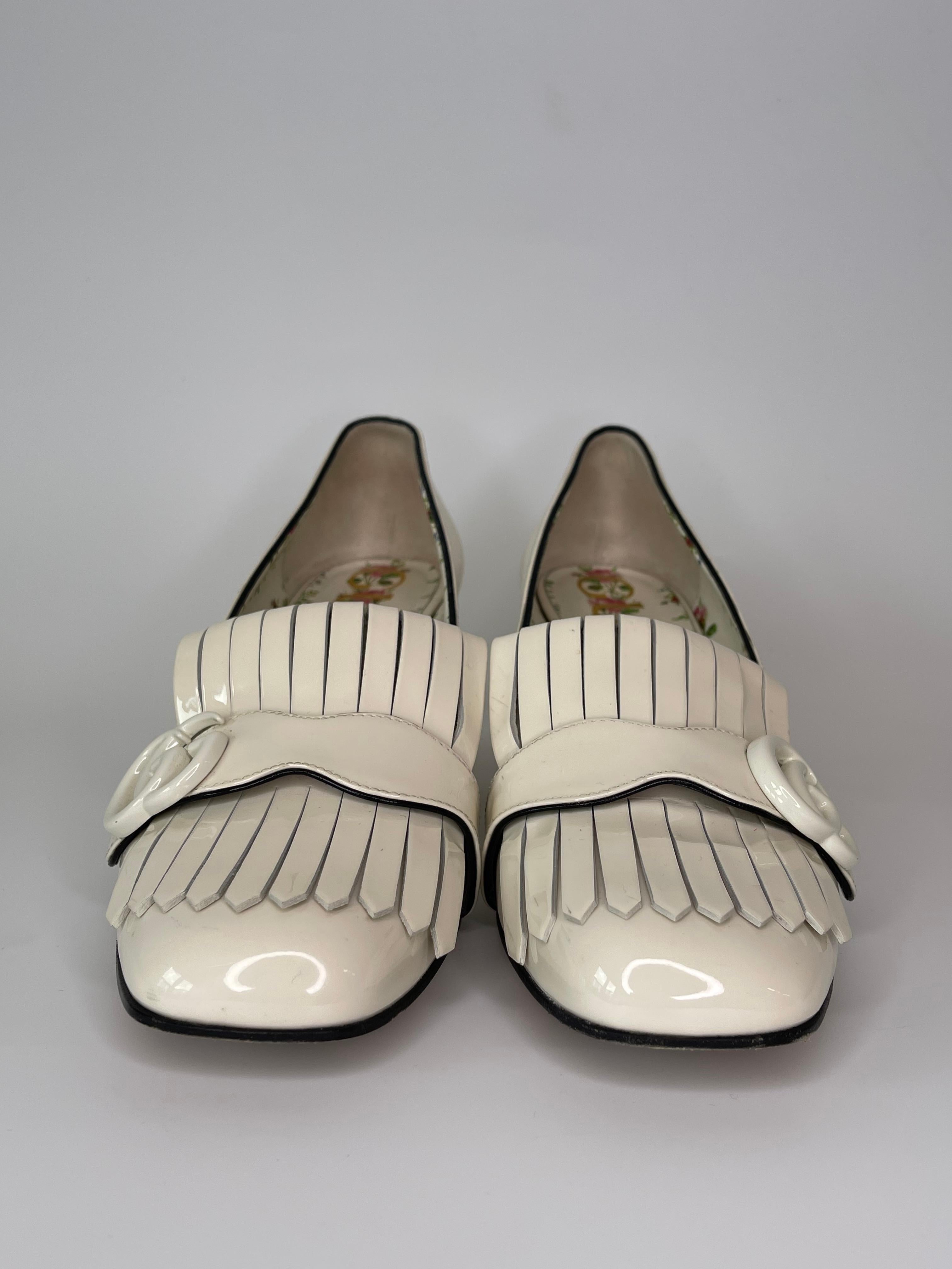 These Gucci GG Marmont heels are a classic design, easy to wear with an almond toe, and fringes with the iconic GG design set at the top of the opening. Very good condition. 

COLOR: Ivory
MATERIAL: Patent leather
ITEM CODE: 474510
SIZE: 39 EU / 8