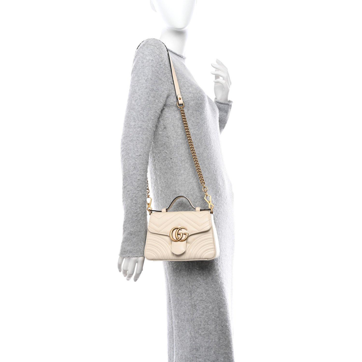 GUCCI GG MARMONT CALFSKIN MATELASSE SHOULDER BAG WHITE MINI

This Gucci GG Marmont shoulder bag is crafted from smooth, supple white calfskin leather finished with a chevron Matelassé stitch. It features a leather handle and a long aged gold chain