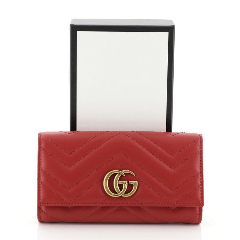 This Gucci GG Marmont Continental Wallet Matelasse Leather, crafted from red matelasse leather, features interlocking GG logo and aged gold-tone hardware. Its snap closure opens to a red leather interior with gusseted open compartments, middle zip