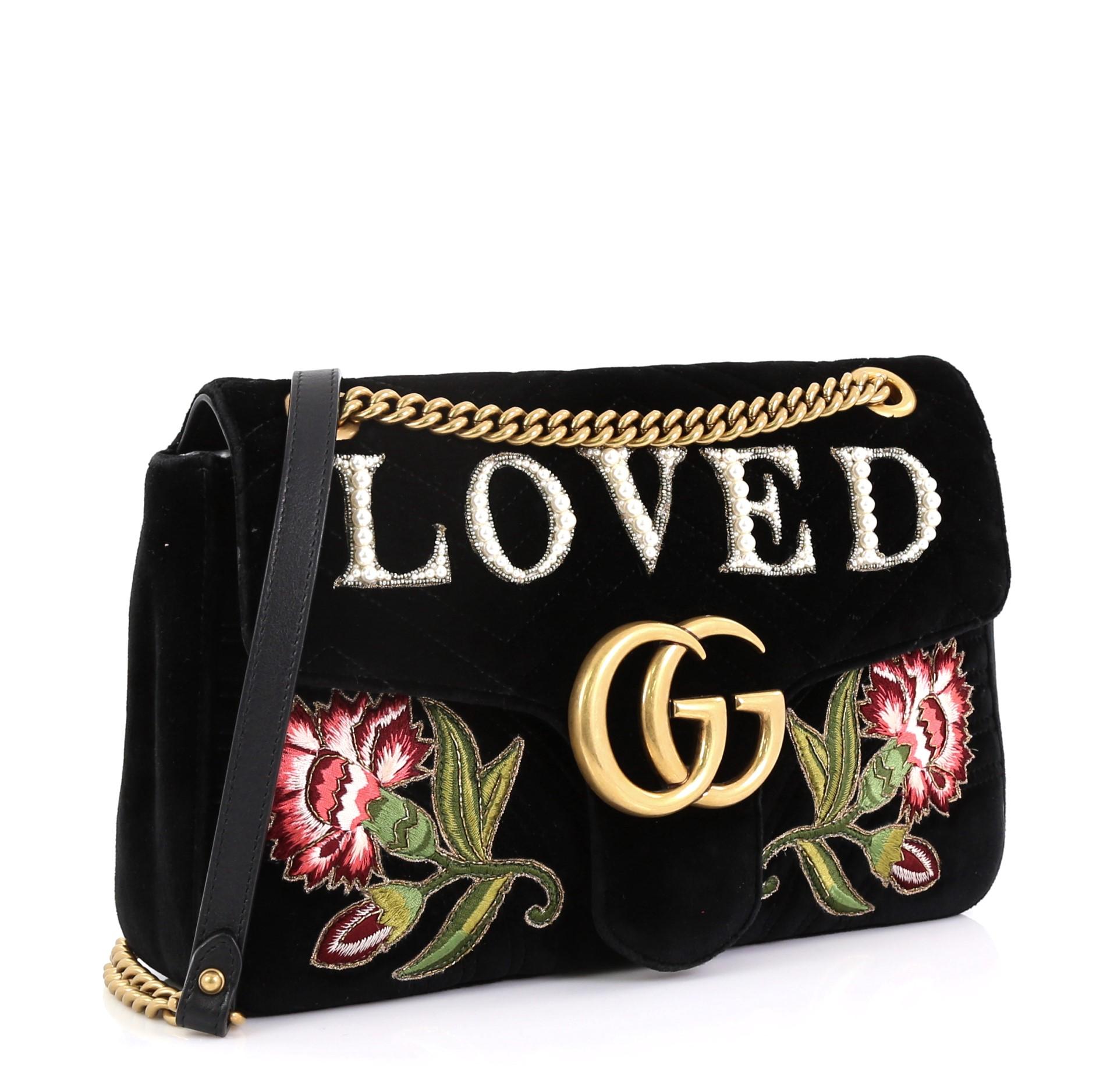 Die Gucci GG Marmont Flap Bag Embroidered Matelasse Velvet Medium aus schwarzem Matelassesamt verfügt über einen Schulterriemen mit Kettengliedern und Lederpad, aufgestickte Blumen und Swarovski-Perlen, die das Wort Loved