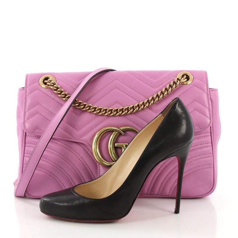 This Gucci GG Marmont Flap Bag Matelasse Leather Medium, crafted from purple matelasse leather, features a chain link strap with leather pad, flap top with GG logo, and aged gold-tone hardware. Its push-lock closure opens to a nude microfiber
