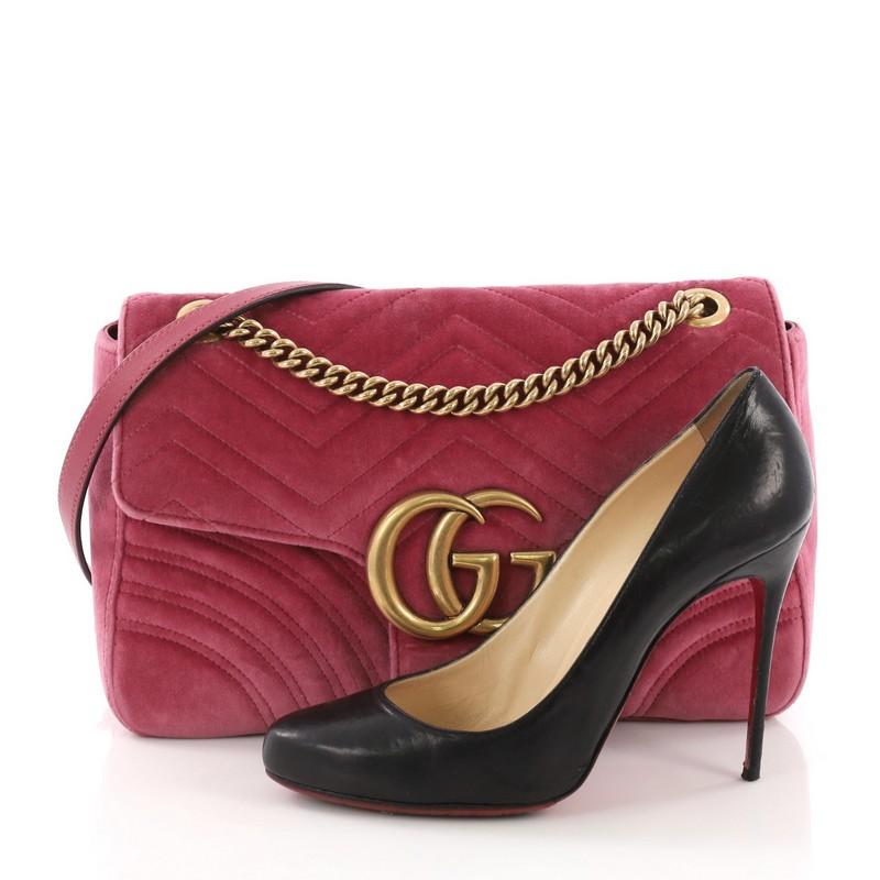This Gucci GG Marmont Flap Bag Matelasse Velvet Medium, crafted from pink matelasse velvet, features a chain link strap with leather pad, flap top with GG logo, and aged gold-tone hardware. Its push-lock closure opens to a blue satin interior with