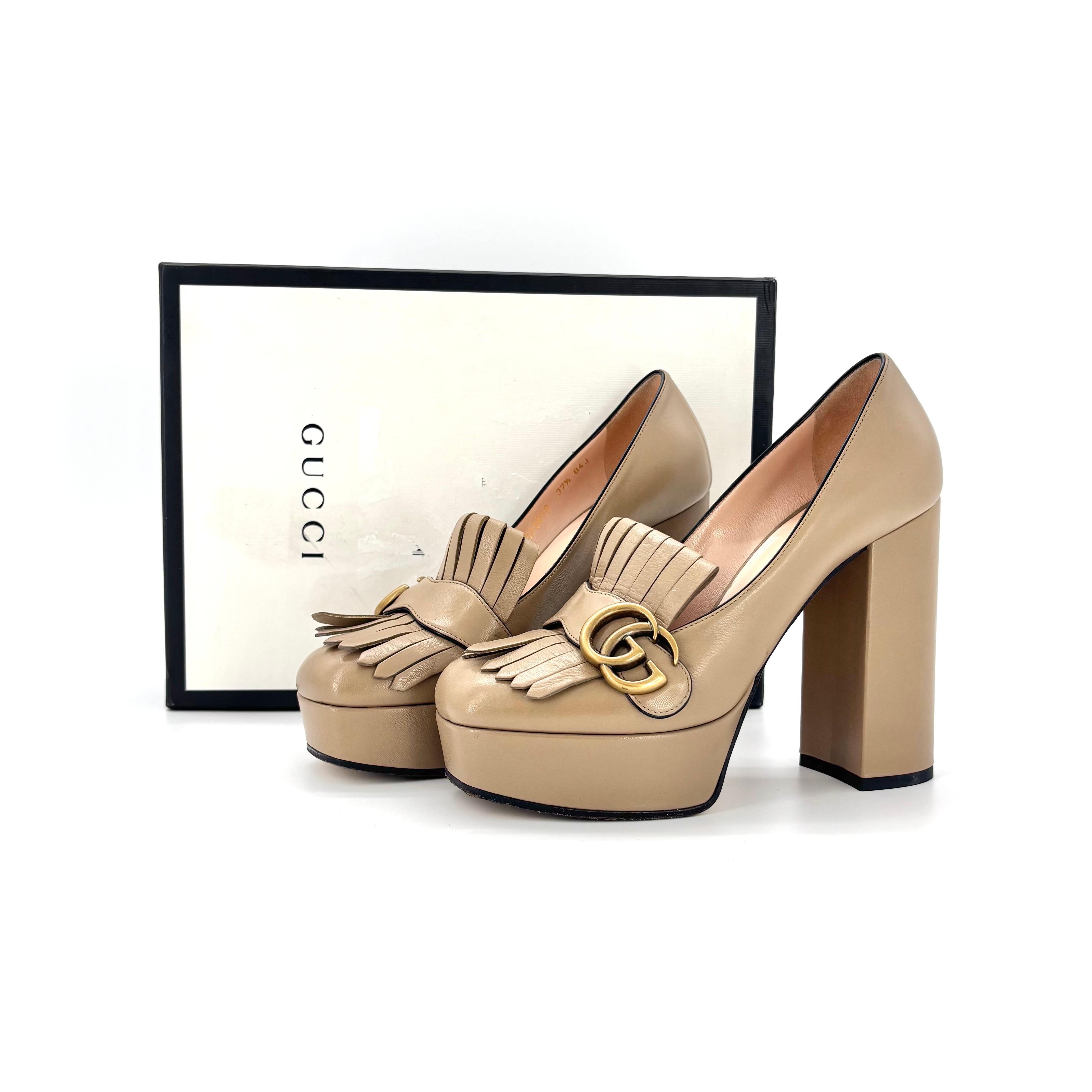 Gucci Marmont, mocassino con zeppa e frange

Colore Teak 
Taglia 37.5EU
Altezza del tacco 5in

Tomaia in pelle
Ferramenta con finitura in ottone a doppia G
Suola con plateau rivestito
Abbellimento con frange sulla tomaia
Tacco a blocco
Prodotto in