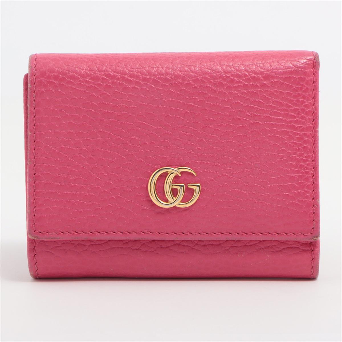 Die Gucci GG Marmont Leather Compact Wallet in Pink ist ein elegantes und kompaktes Accessoire, das Luxus und modernes Design nahtlos miteinander verbindet. Das sorgfältig aus Glattleder gefertigte Portemonnaie ist mit dem kultigen GG Marmont