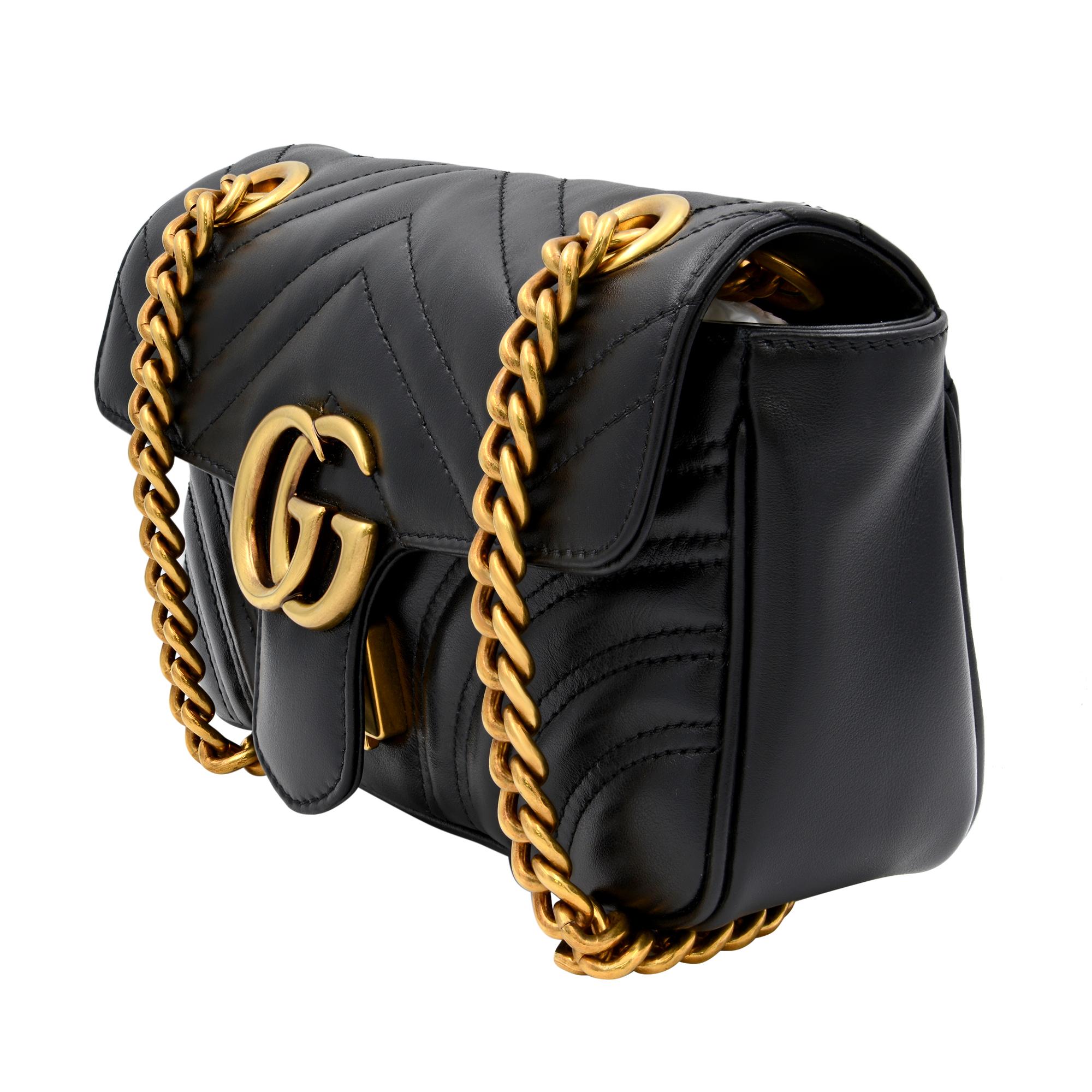 This small Gucci GG Marmont chain shoulder black leather bag has a softly structured shape and an oversized flap closure with Double G hardware. The sliding chain strap can be worn multiple ways, changing between a shoulder and a top handle bag.