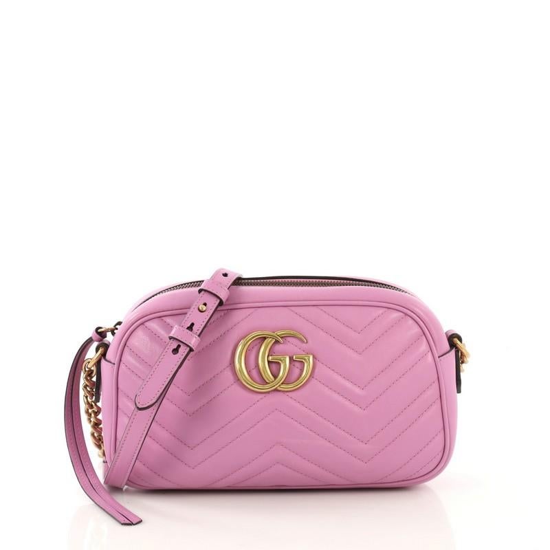 This Gucci GG Marmont Shoulder Bag Matelasse Leather Small, crafted from purple matelasse leather , features a leather strap with chain links, GG logo at the front, and aged gold-tone hardware. Its zip closure opens to a beige microfiber interior