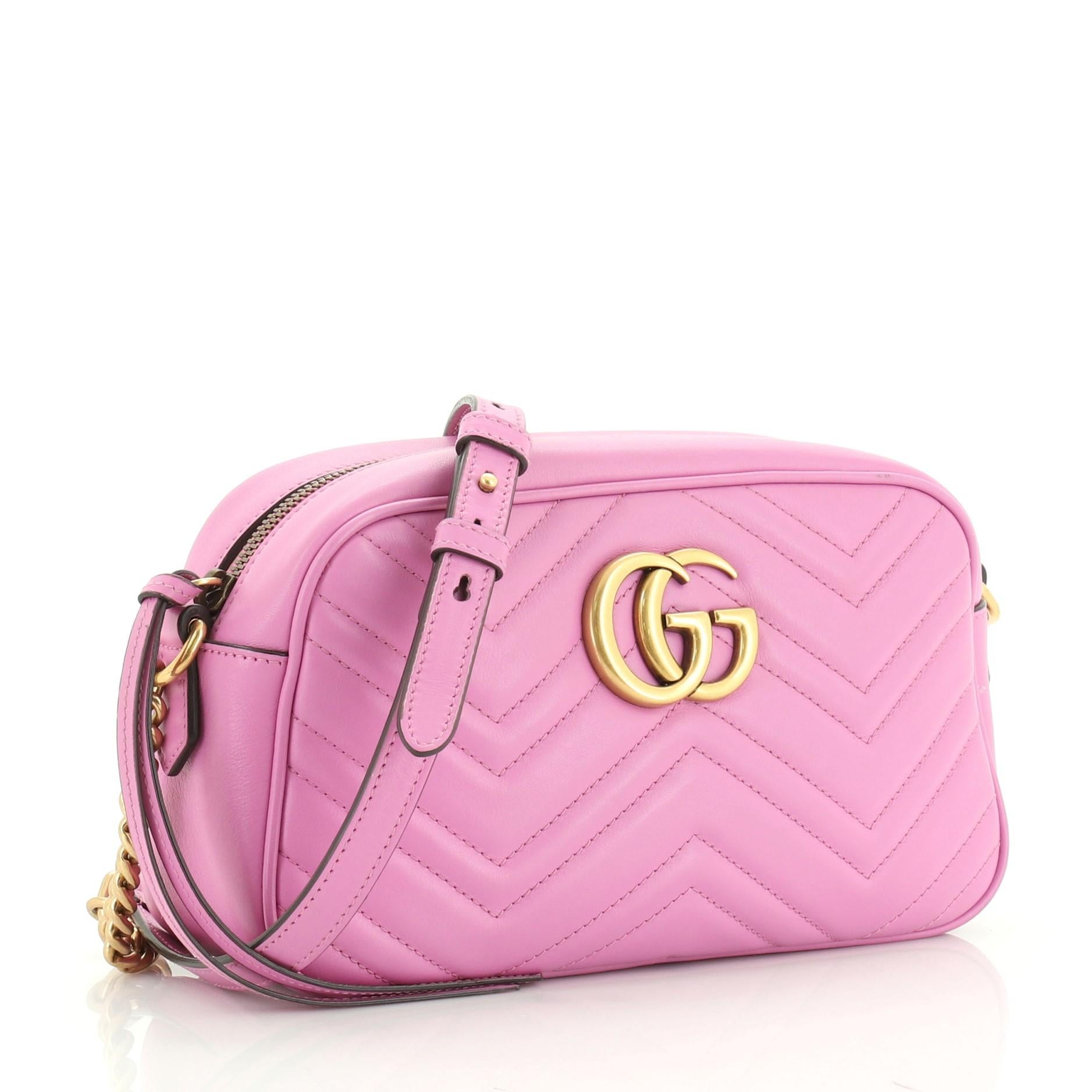 This Gucci GG Marmont Shoulder Bag Matelasse Leather Small, crafted from pink matelasse leather, features a leather strap with chain links, GG logo at the front, and aged gold-tone hardware. Its zip closure opens to a neutral microfiber interior