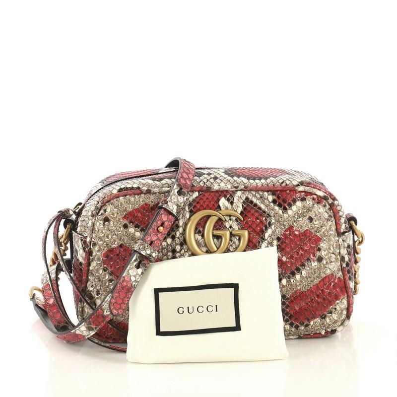 This Gucci GG Marmont Shoulder Bag Matelasse Python Small, crafted from genuine pink and neutral printed python, features chain links with adjustable shoulder strap, GG logo at the front, and aged gold-tone hardware. Its zip closure opens to a pink