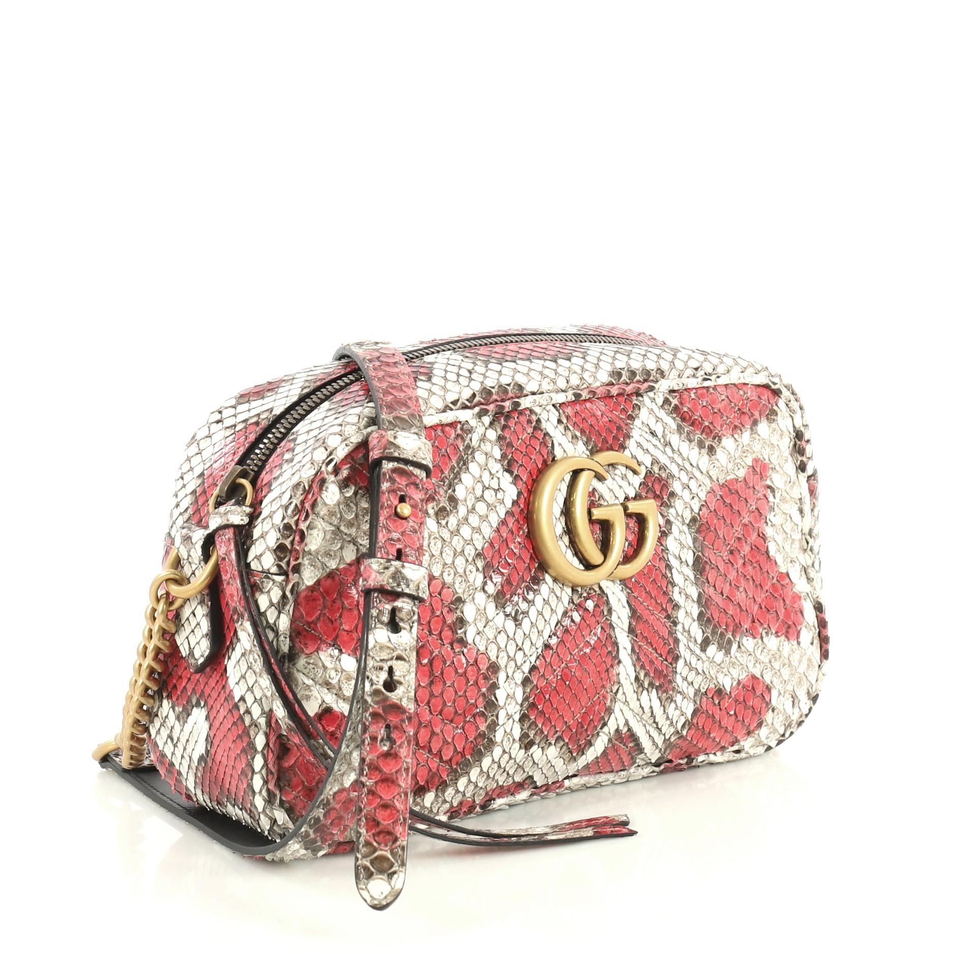 This Gucci GG Marmont Shoulder Bag Matelasse Python Small, crafted from genuine gray, red, and multicolor printed python skin, features chain links with adjustable shoulder strap, GG logo at the front, and aged gold-tone hardware. Its zip closure