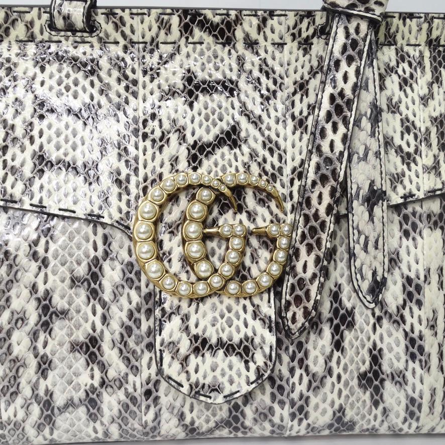 Do not miss out on this spectacular and rare snakeskin Gucci handbag! A sleek satchel style handbag from Gucci's Marmont collection is adorned in an eye catching snakeskin with contrasting golden hardware. The star of the show is the interlocking GG