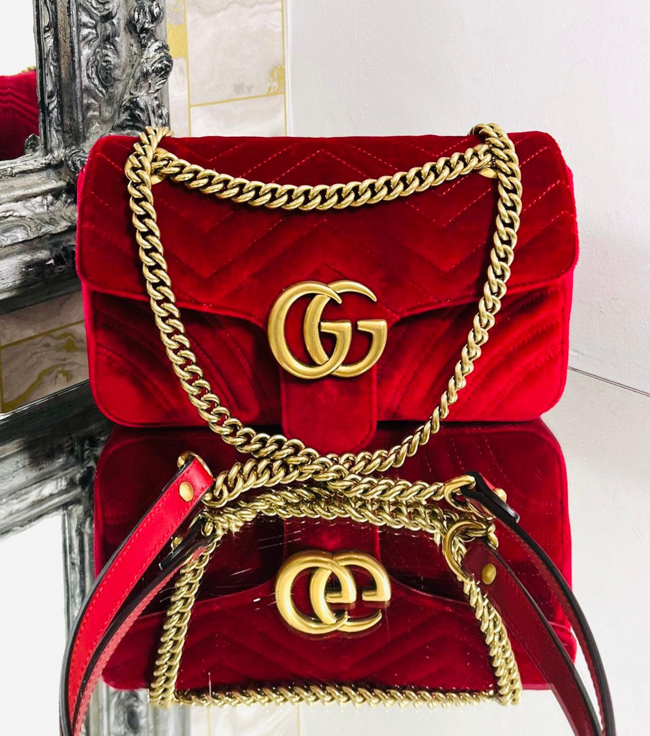 Gucci GG Marmont Small Velvet Bag

Hibiscus red shoulder bag designed with chevron quilting.

Detailed with heart stitched to rear and 'GG' logo front flap closure.

Featuring aged gold hardware and chain link strap with leather shoulder