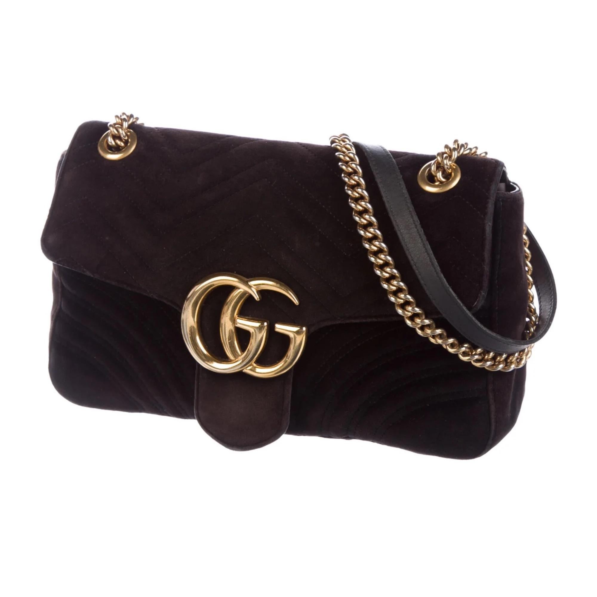 This shoulder bag is made of soft velvet in black with matelassé stitching. This bag features a long gold chain-link shoulder strap with a leather shoulder pad, a front flap with the interlocking GG logo and push-lock closure. The interior is
