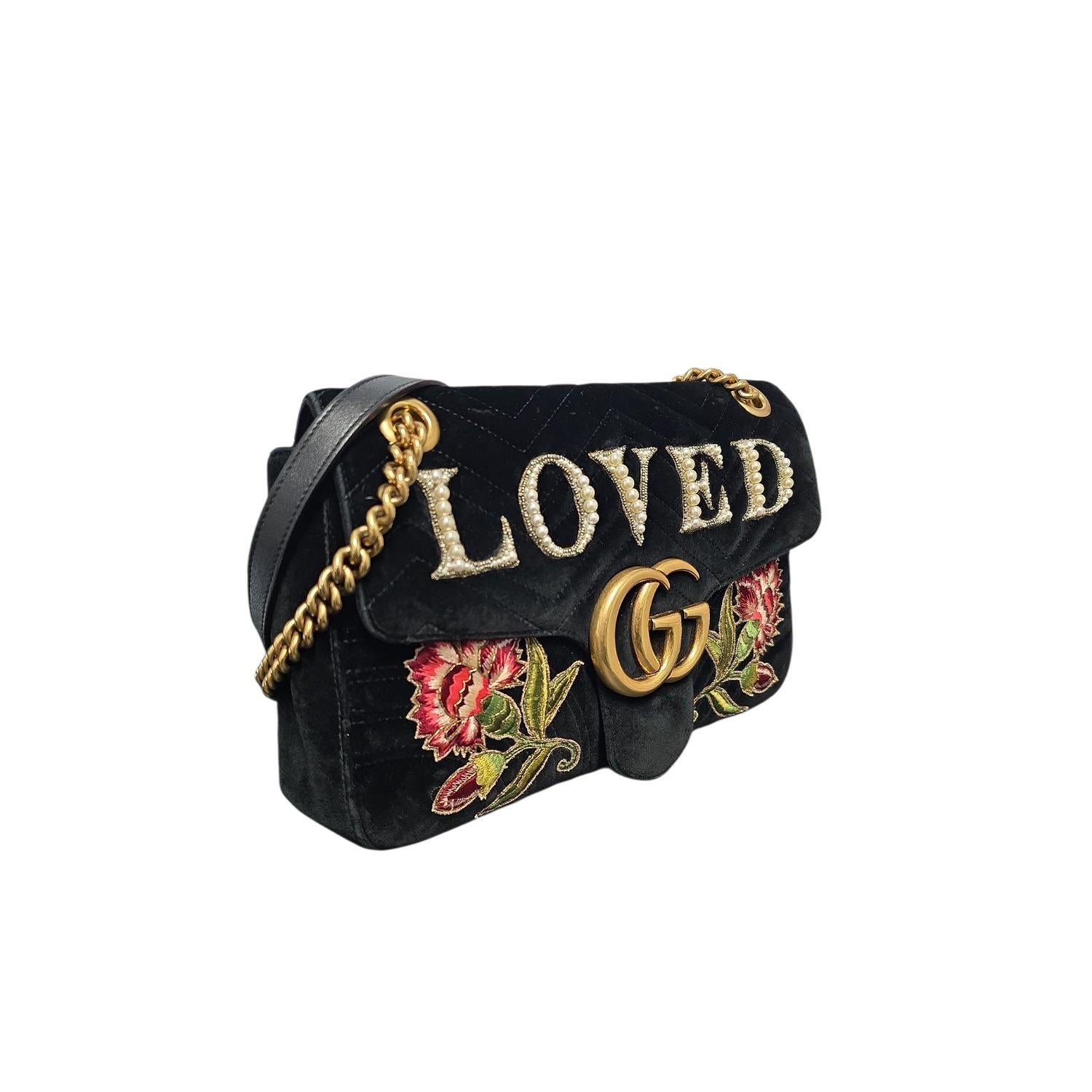 Ce sac à rabat Marmont en velours brodé de Gucci est réalisé en somptueux velours noir matelassé et garni de cuir raffiné. Il présente des broderies florales complexes rehaussées de fausses perles délicates. La sangle en chaîne en or vieilli poli