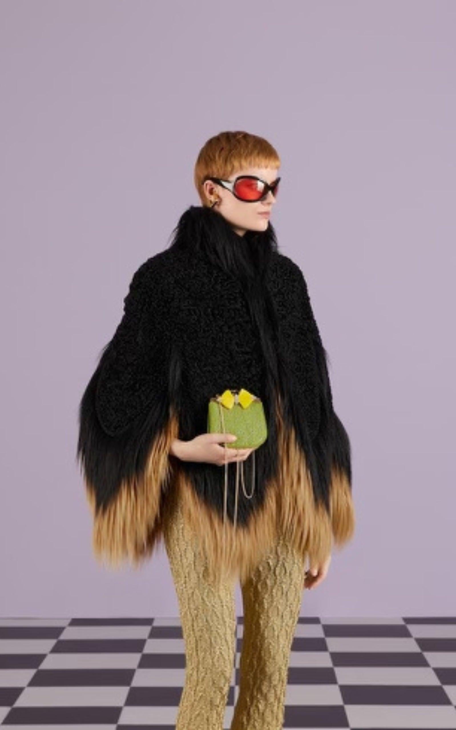 Indulge in the timeless elegance of this Gucci clutch, featuring a sophisticated silhouette adorned with vibrant plexi bows. Crafted with luxurious green GG moire fabric, accented by golden details and a microfiber lining with a suede-like finish.