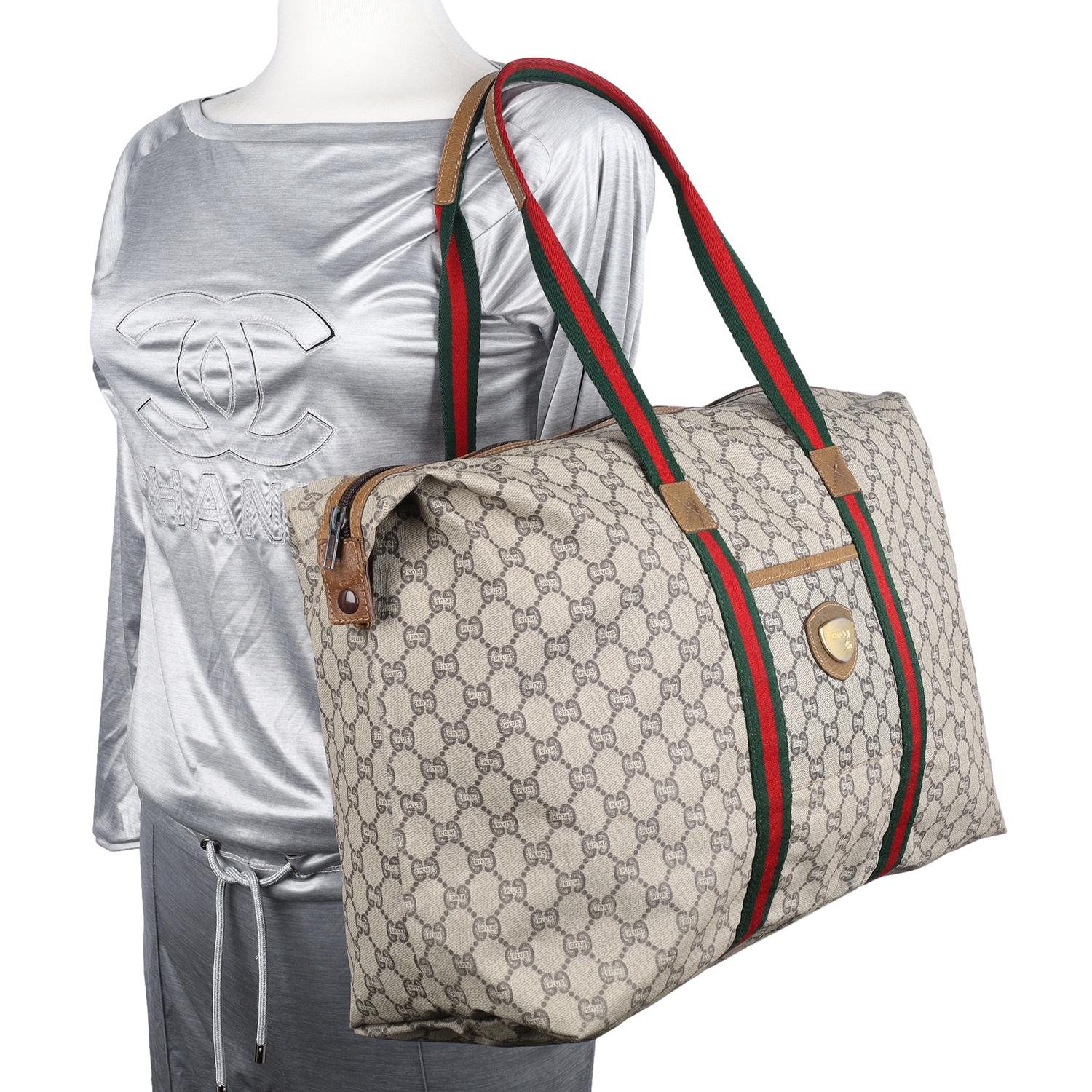 Authentic Gucci brown monogram canvas tote travel bag. Travel with an attitude with this Gucci beige and red GG Plus large tote travel bag. Features durable GG plus coated canvas with Supreme stripe and Supreme handle, zipper top closure, snap side