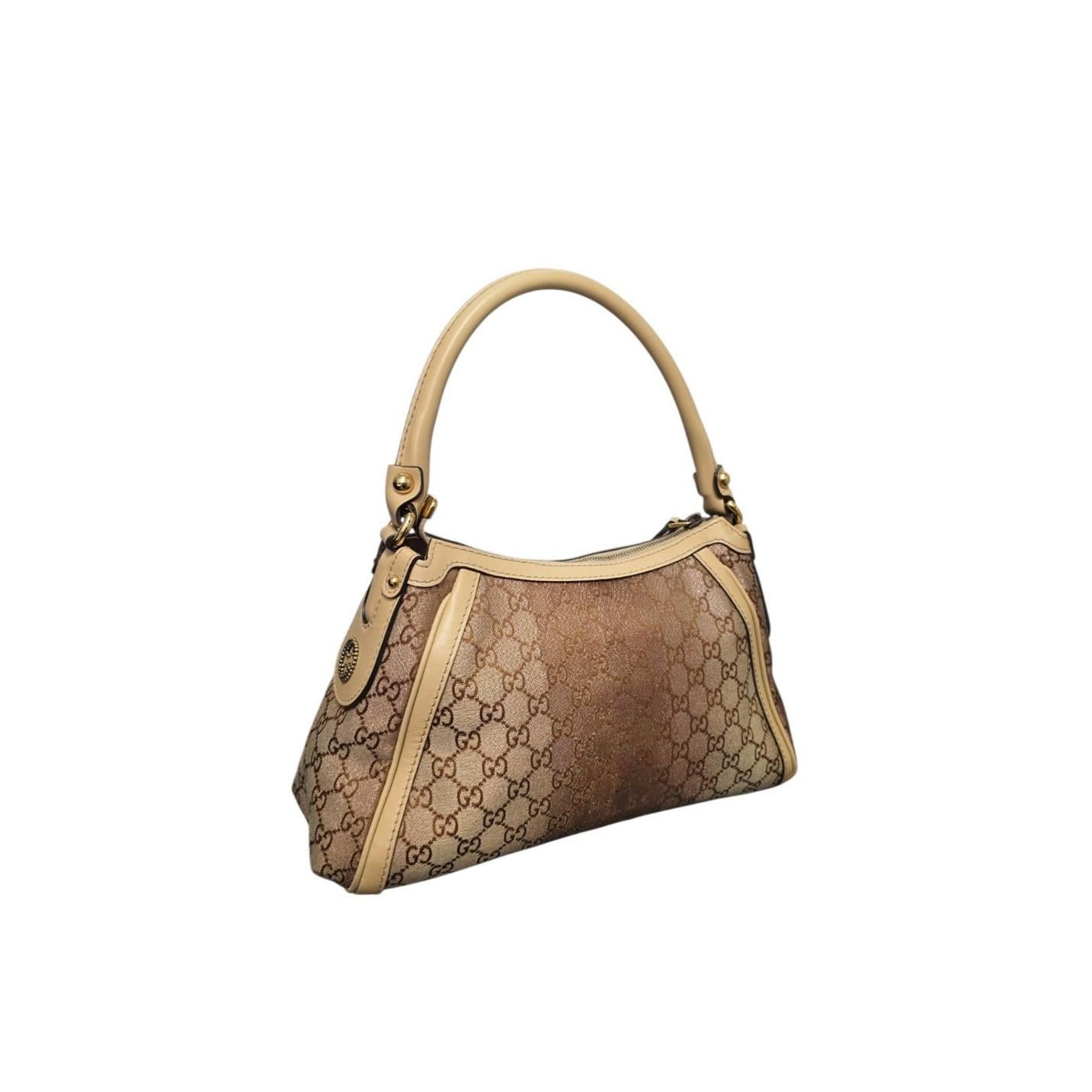 Le petit hobo Scarlett en toile Gucci GG Monogram Shimmer présente une finition cuivre métallique sur la toile signature de Gucci, avec une poignée en cuir et des accents dorés pour un look élégant et durable. Son intérieur doublé de lin comprend