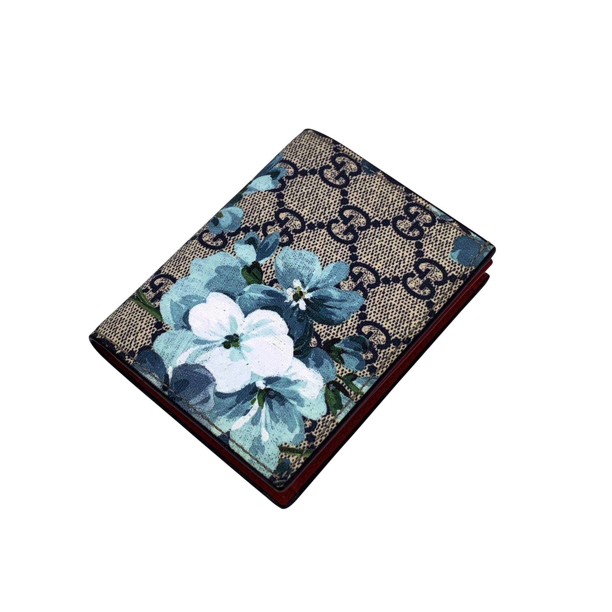 Indulge in understated luxury with this Gucci 'Blooms' Credit Card Holder Wallet, a perfect fusion of style and functionality. Crafted from the iconic GG Supreme monogram canvas wiyh blue floral print. Red leather interior. Button closure. The