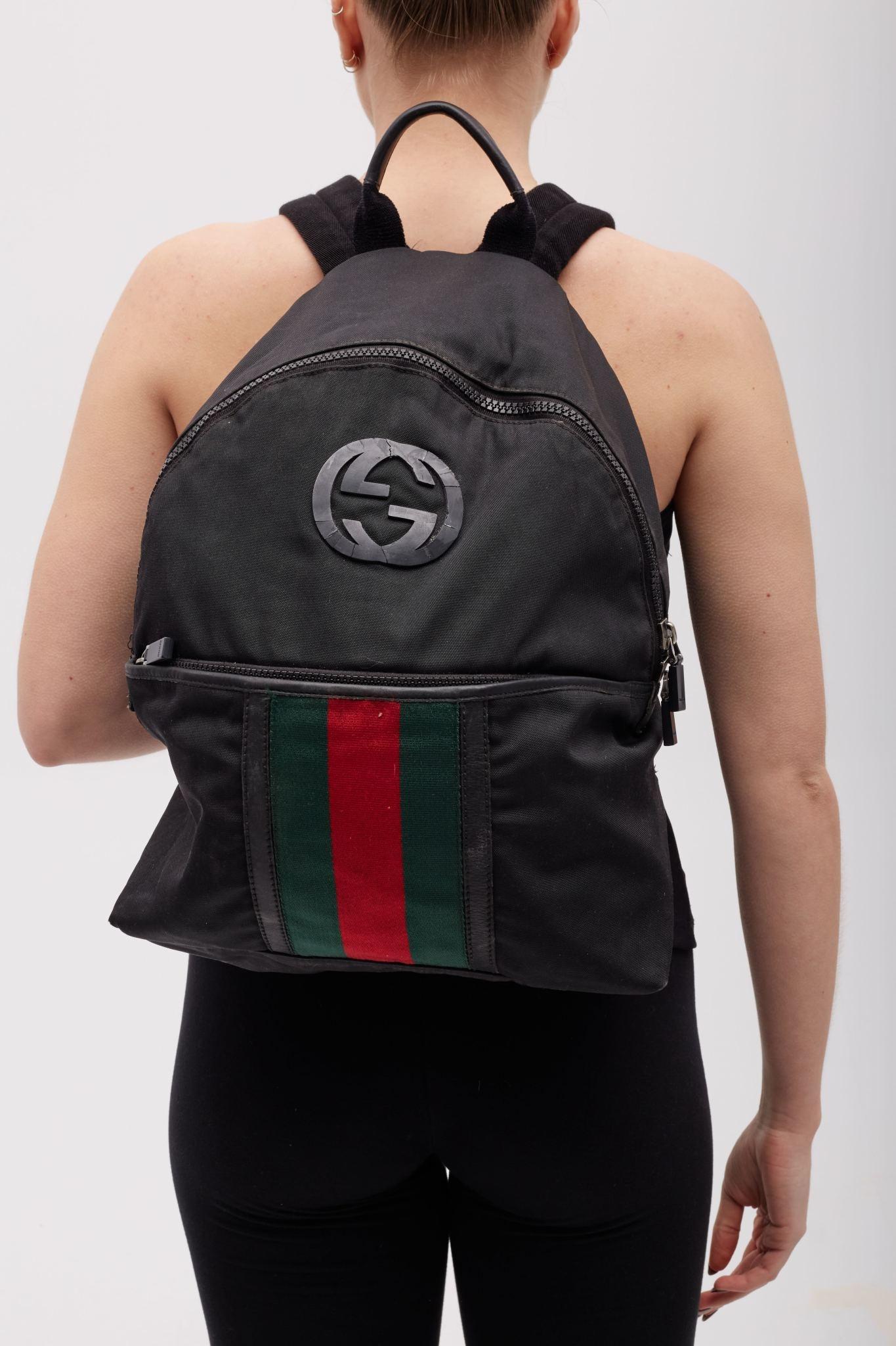 This backpack is made of black Gucci GG monogram canvas. The bag has an adjustable shoulder strap and a top zipper that opens to a black fabric interior with a zipper pocket. 

Color: black with web
Material: canvas with leather details
Style No.