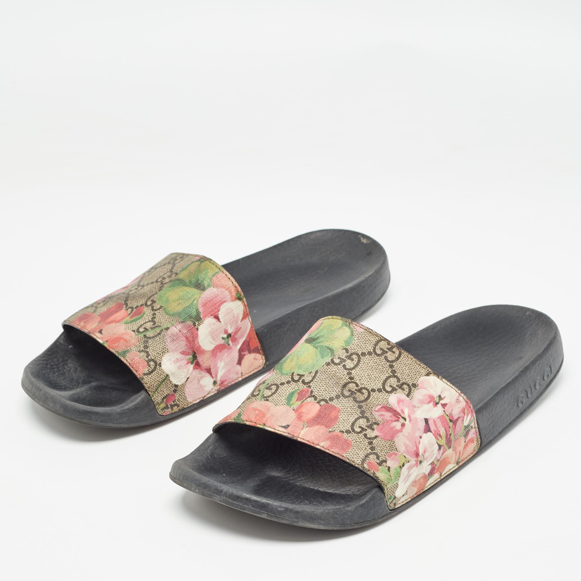 Gucci's rubber slides for women have the GG canvas with Blooms print on the uppers. They're perfect for the beach, vacation days, or everyday use.