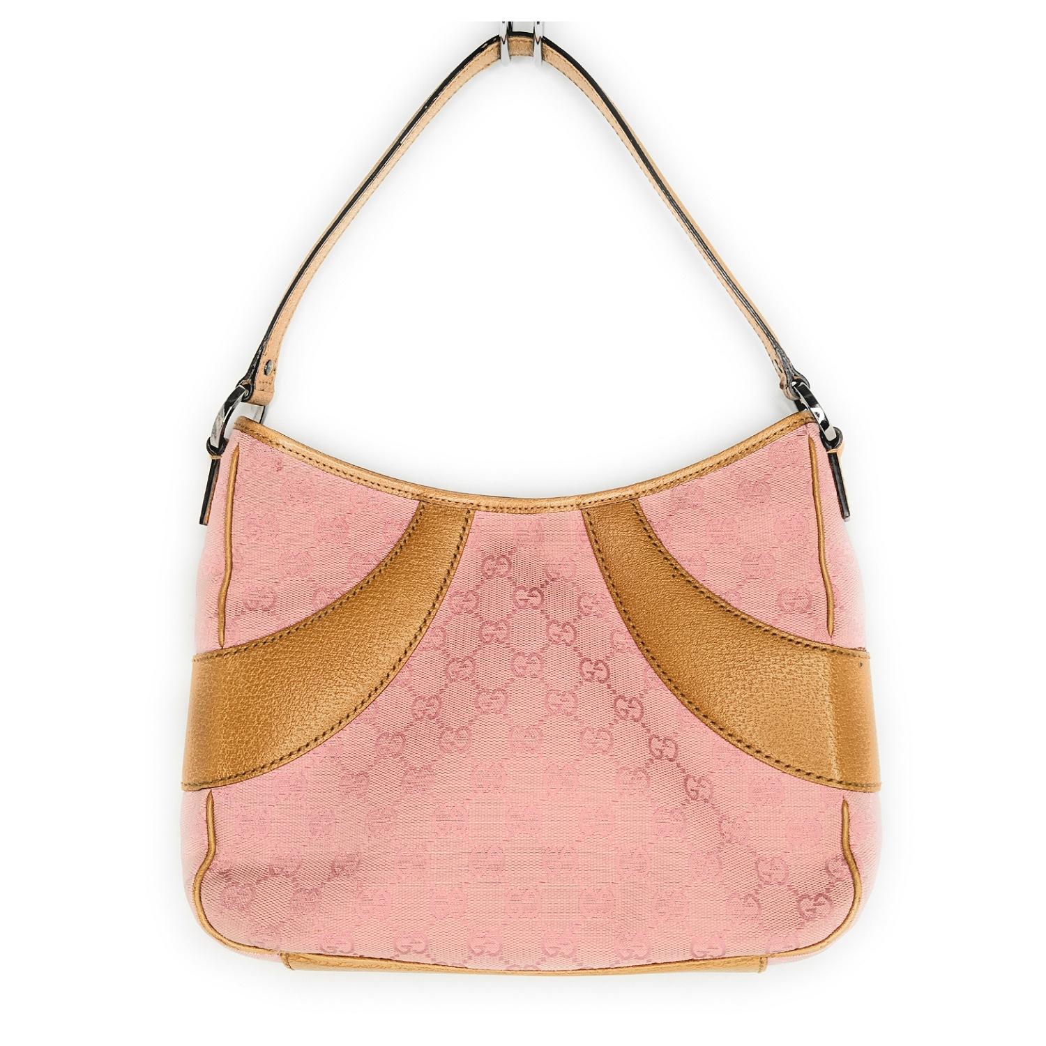 It's a chic Gucci handbag for any occasion. It features the GG Monogram canvas in pink with tan leather trim, a flat handle, and ruthenium-tone hardware. The interior has a brown textile lining with a zip pocket and a snap magnetic closure. It's a