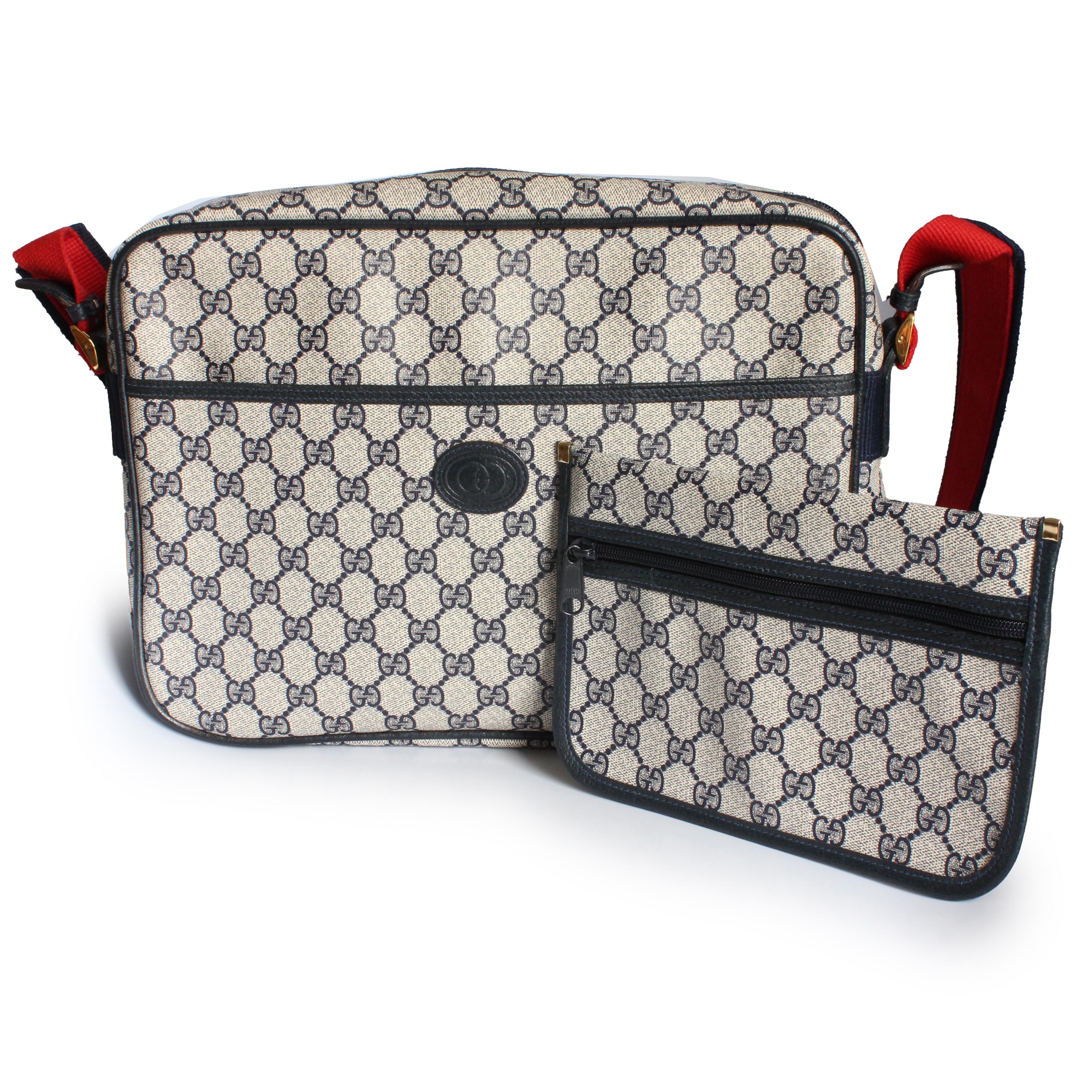 Authentic, preowned, vintage Gucci travel messenger bag with removable pouch, likely made in the 90s.  Made from navy GG Plus canvas, it's trimmed in navy leather and features a red and blue cloth shoulder strap.  This fabulous travel bag also comes