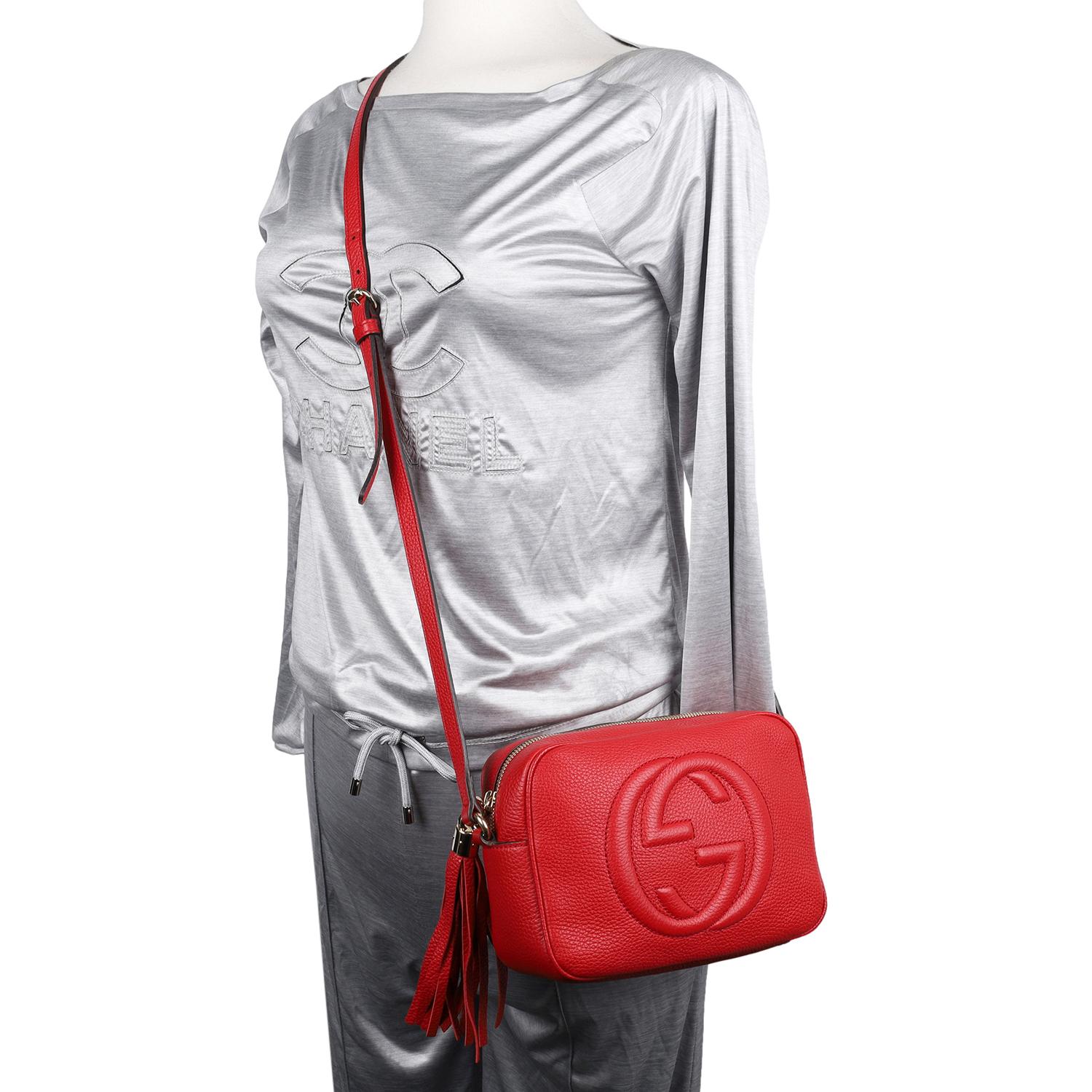 Authentic, pre-owned Gucci GG Red Soho Disco leather cross body bag. This classic Gucci red leather cross body bag makes a perfect everyday bag. Features GG logo on the front, zipper top closure with fringe pull tab, roomy interior with 2 slip