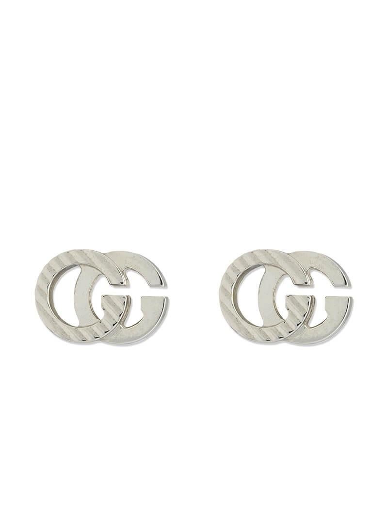 Appearing as the defining feature of a pair of stud earrings in white gold, the Double G pays tribute to the House's history. The monogram detail is enhanced with engraved diagonal stripes, created using the guilloche technique. The intricate