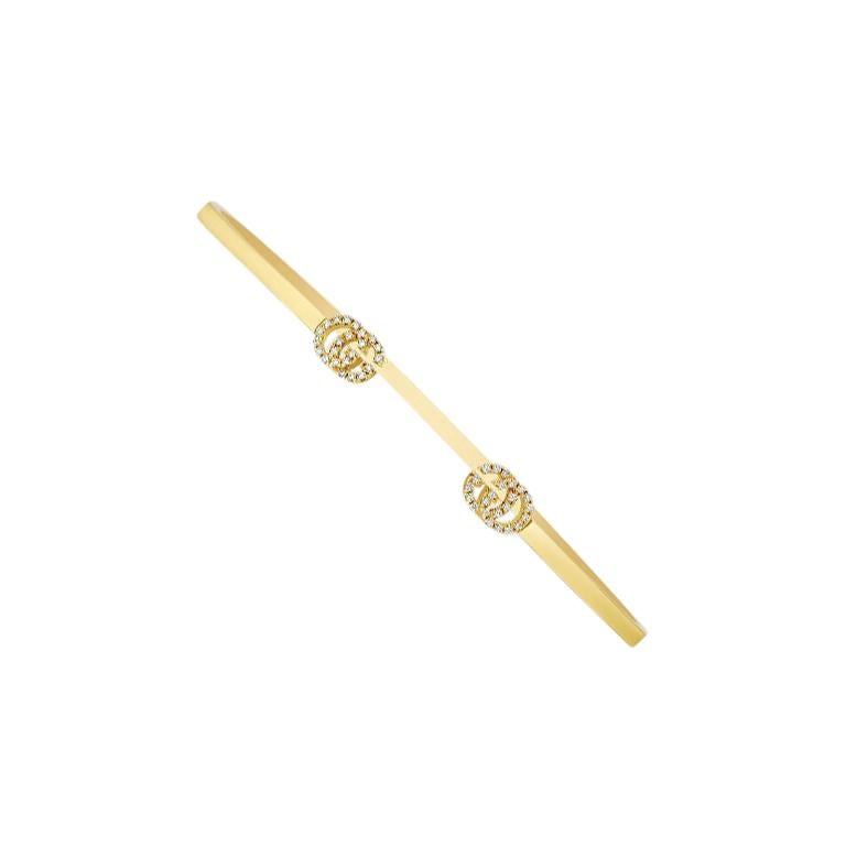Cette manchette en or jaune 18 carats de Gucci est ornée du célèbre motif Double G, bordé de diamants blancs étincelants. À porter seul ou à associer à toute autre pièce du créateur excentrique. Bracelets pour dames Gucci. SKU : YBA481662001.