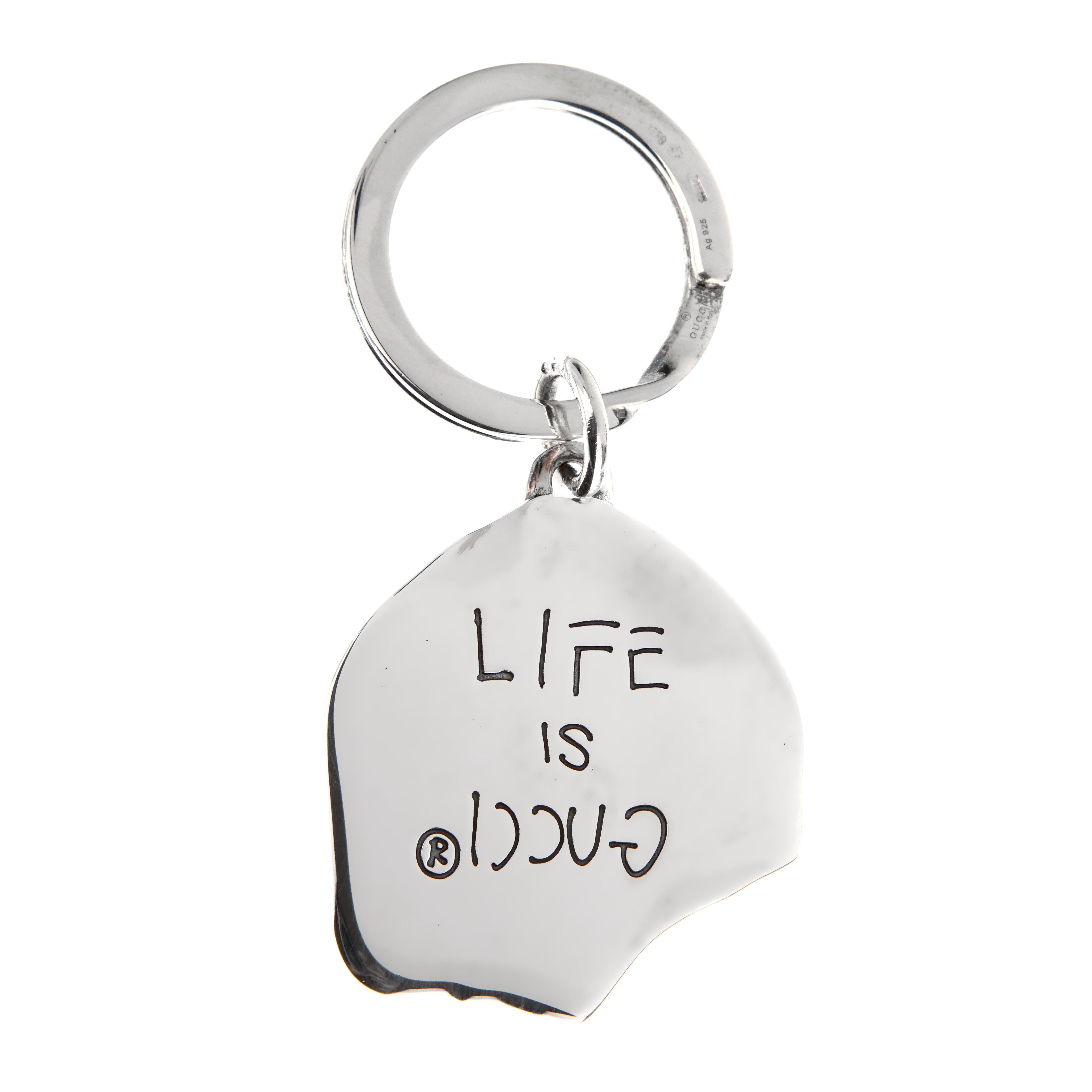 Porte-clés en forme de tête de mort Gucci GG, en argent sterling poli. Ce modèle présente un motif de tête de mort stylisé, embossé du logo emblématique 