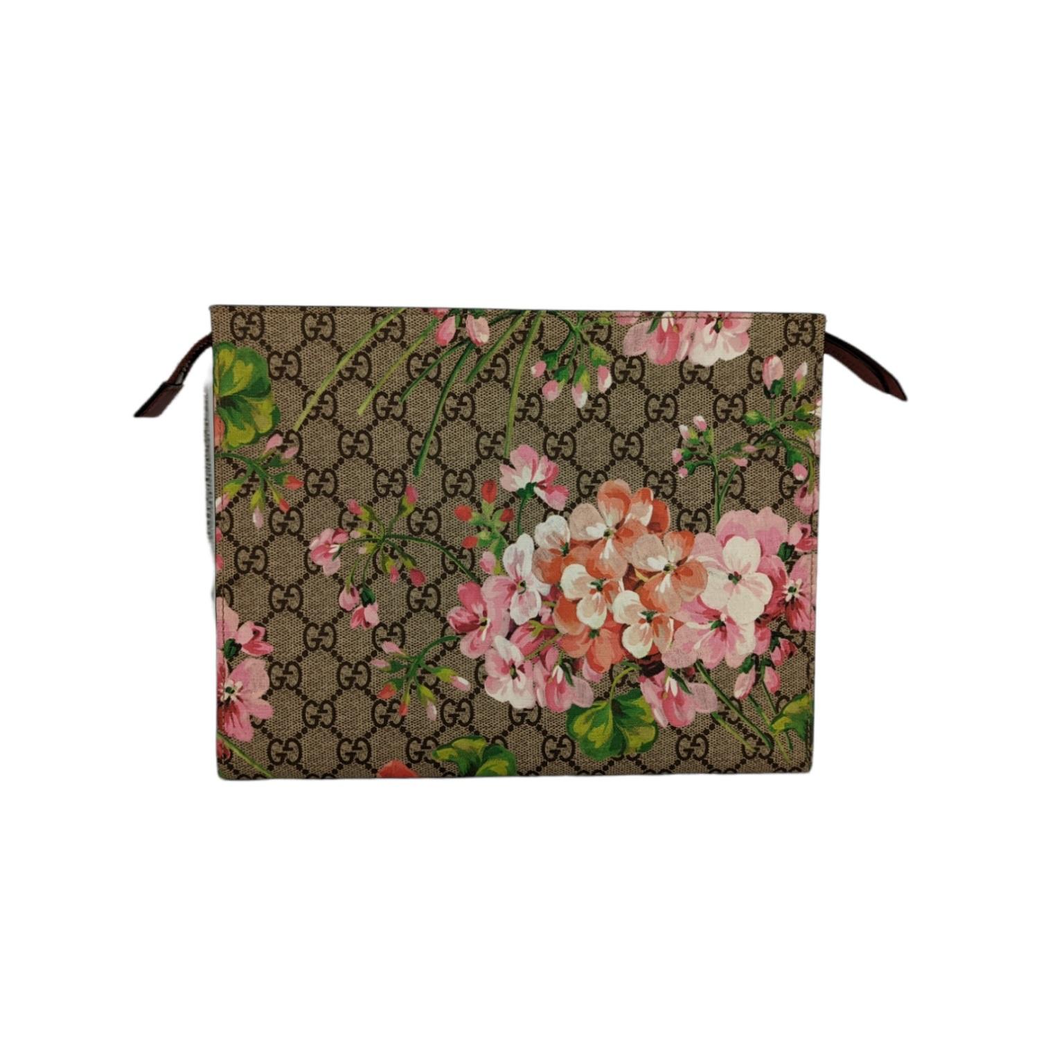 GUCCI GG Supreme Monogram Blooms Print Large Cosmetic Case in Antique Rose. This pouch is crafted of GG monogram coated canvas in brown and beige with a floral pattern overlay. The top zipper opens with a long leather zipper pull to a brown fabric