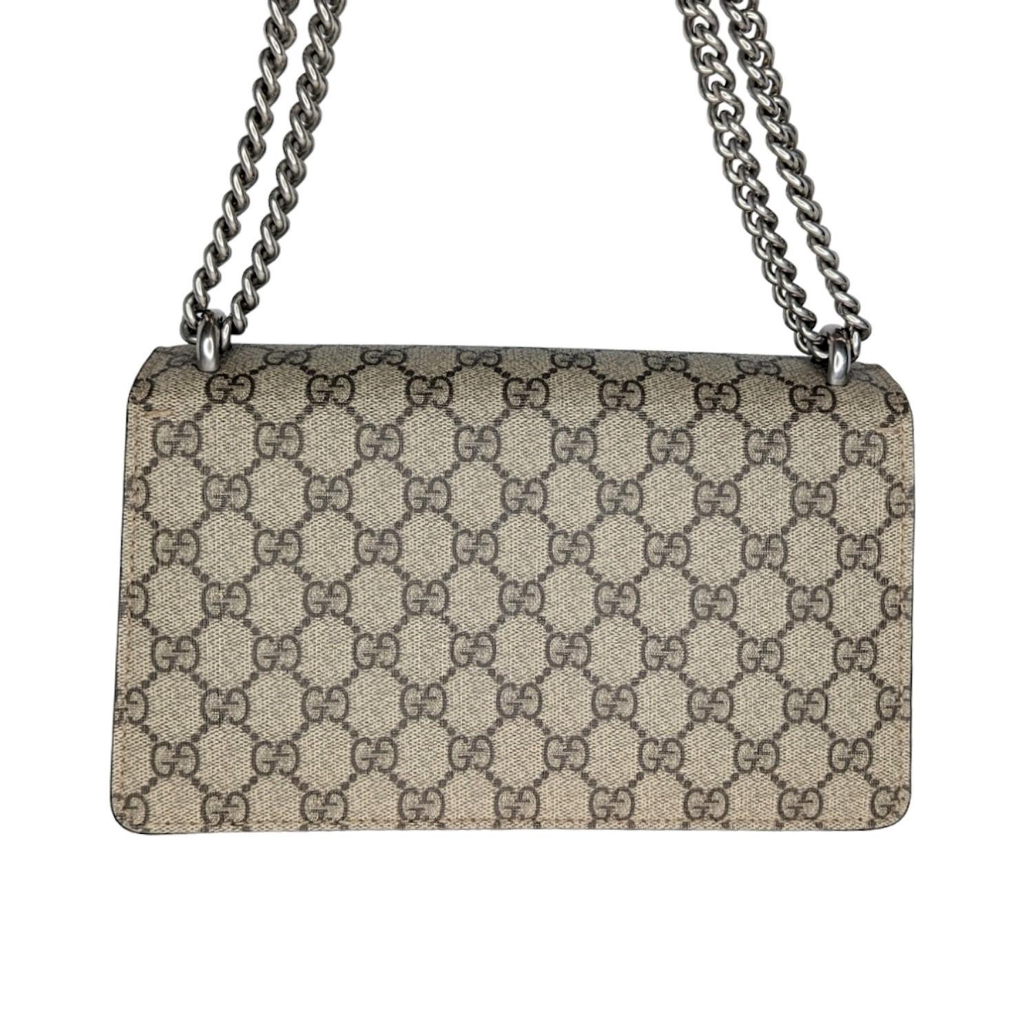 The small Dionysus shoulder bag is presented in the signature GG pattern, trimmed with taupe suede details. The shape is defined by the defining tiger head closure—a unique detail referencing the Greek god Dionysus, who in myth is said to have