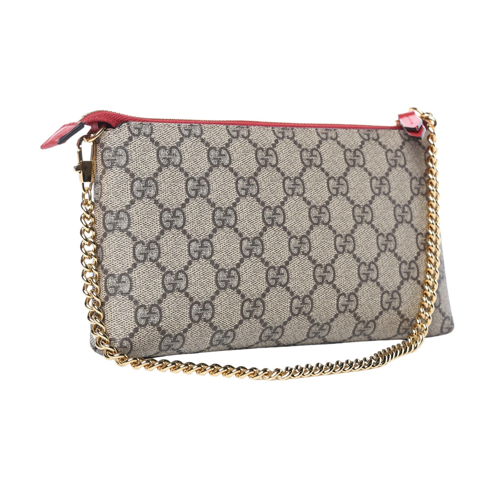 This chain wallet is crafted of GG monogram with heart/snake embroider patch. The bag features a gold shoulder chain and a zipper pull that opens to a beige microfiber interior with a spacious zippered currency compartment and card slots. Red