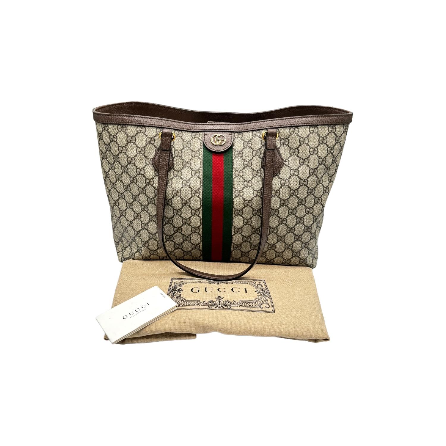 This Gucci GG Supreme Medium Ophidia Tote was made in Italy, and it is finely crafted of the classic Gucci GG Supreme coated canvas exterior with leather trimming and gold-tone hardware features. It has a magnetic top closure that opens to a suede