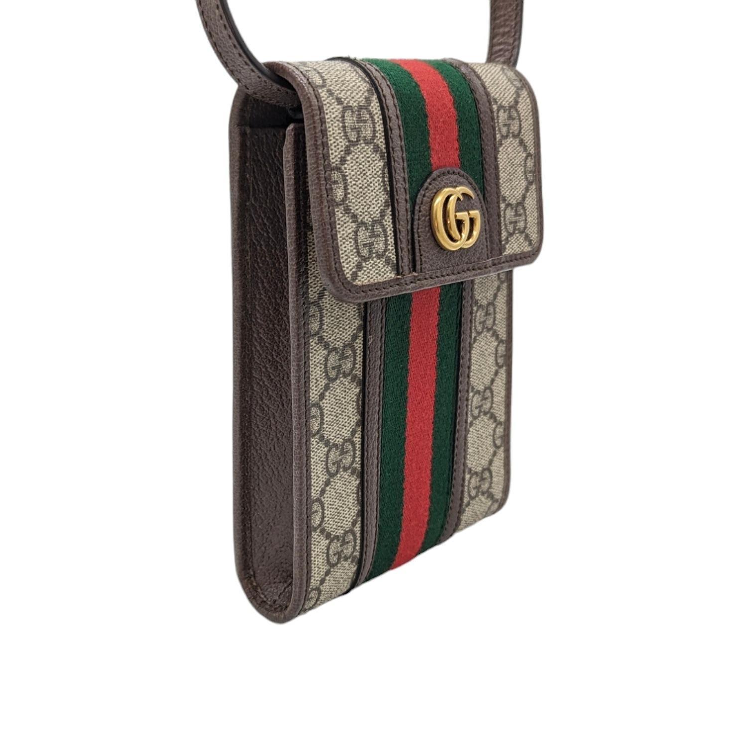 This camera-style crossbody bag is crafted of Gucci GG supreme monogram coated canvas, with brown leather trim. The bag features the signature green and red web stripe design and an adjustable shoulder strap with polished gold hardware. The bag