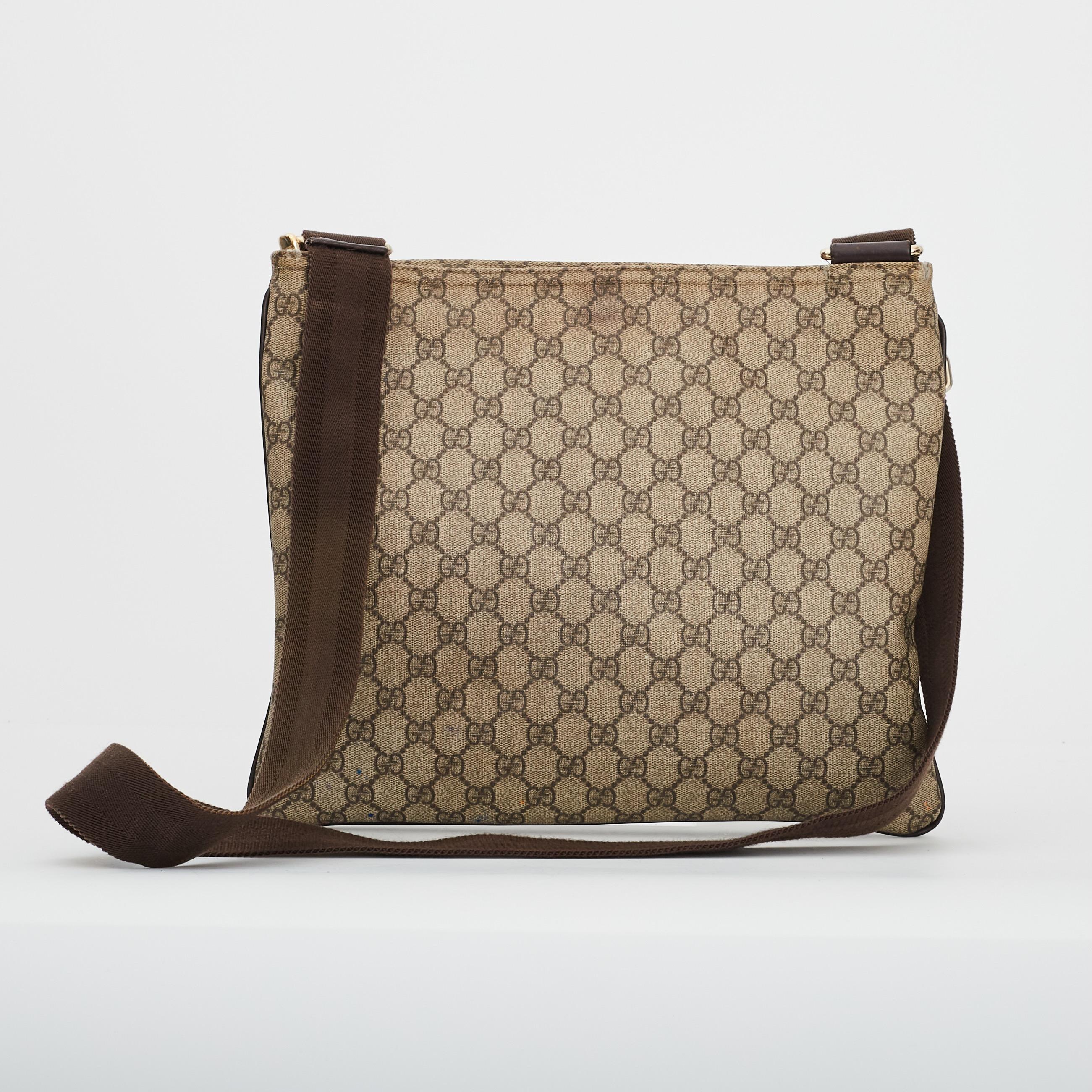 Diese beige/beigefarbene Monogramm-Crossbody-Tasche von Gucci besteht aus beschichtetem GG-Supreme-Canvas mit Lederabschlüssen und einem Schulterriemen aus gewebtem Stoff. Die Tasche wird mit einem Reißverschluss geschlossen und ist innen mit einem
