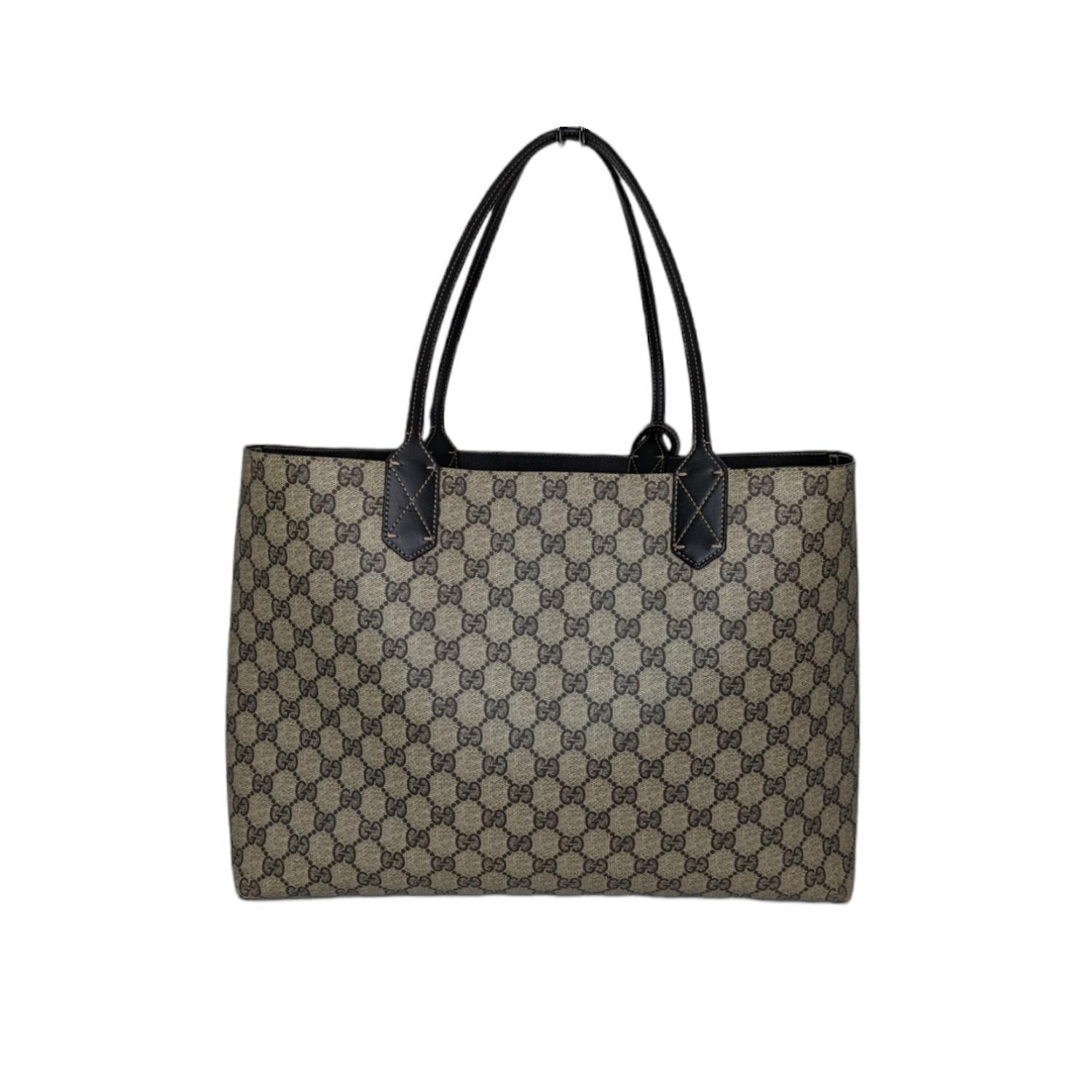 This stylish Medium-size lightweight carryall tote is crafted of classic Gucci GG monogram coated canvas. The bag features very tall leather strap top handles. There is a broad top opening to a reversible black textured calfskin interior that is