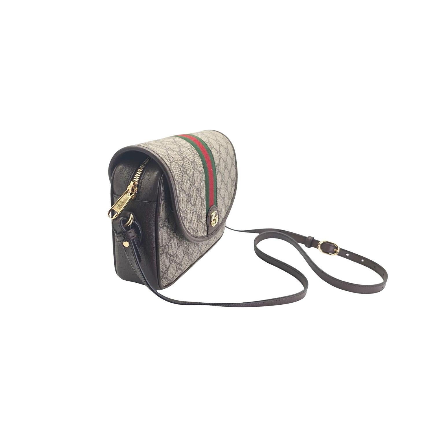 Schwelgen Sie in Luxus mit der Gucci GG Supreme Monogram Small Ophidia Flap Shoulder Bag. Diese Tasche aus beschichtetem Canvas mit GG Supreme Monogram und braunem Lederbesatz strahlt Raffinesse aus. Das rot und marineblau gestreifte Armband mit